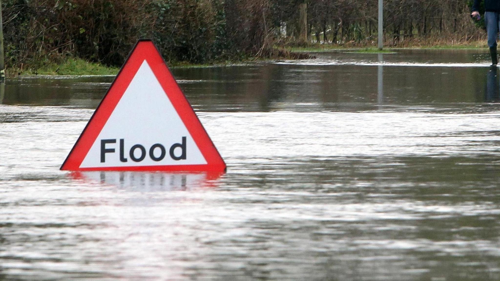 Flood sign and water on the road surface