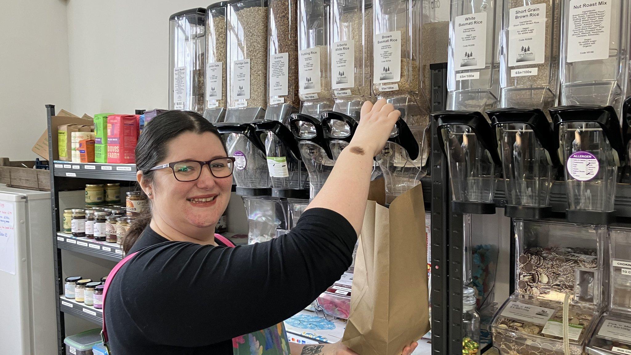 Kirsty Scott pouring rice out of a dispenser into a brown paper bag