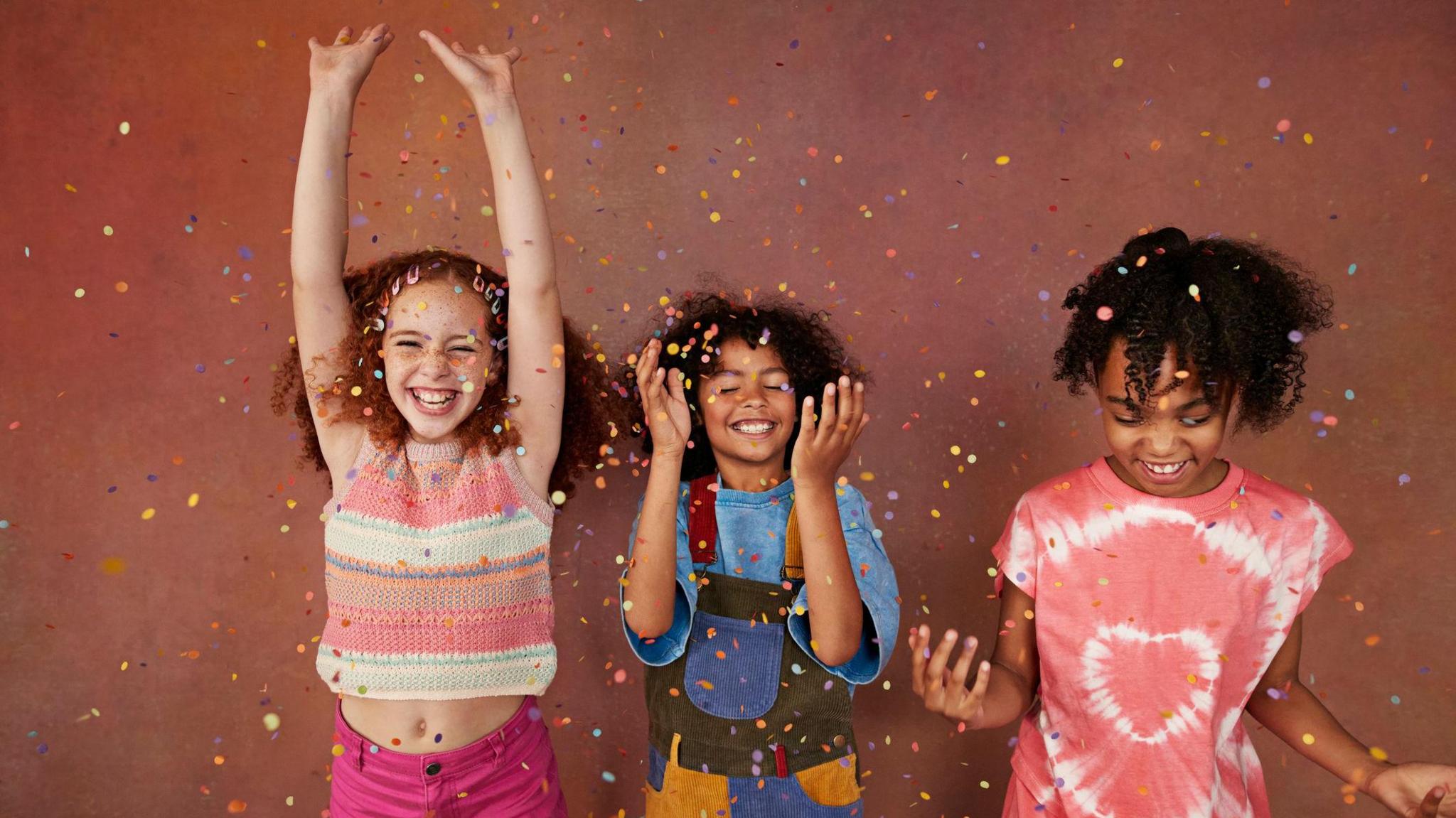 Kids cheering with confetti falling around them.