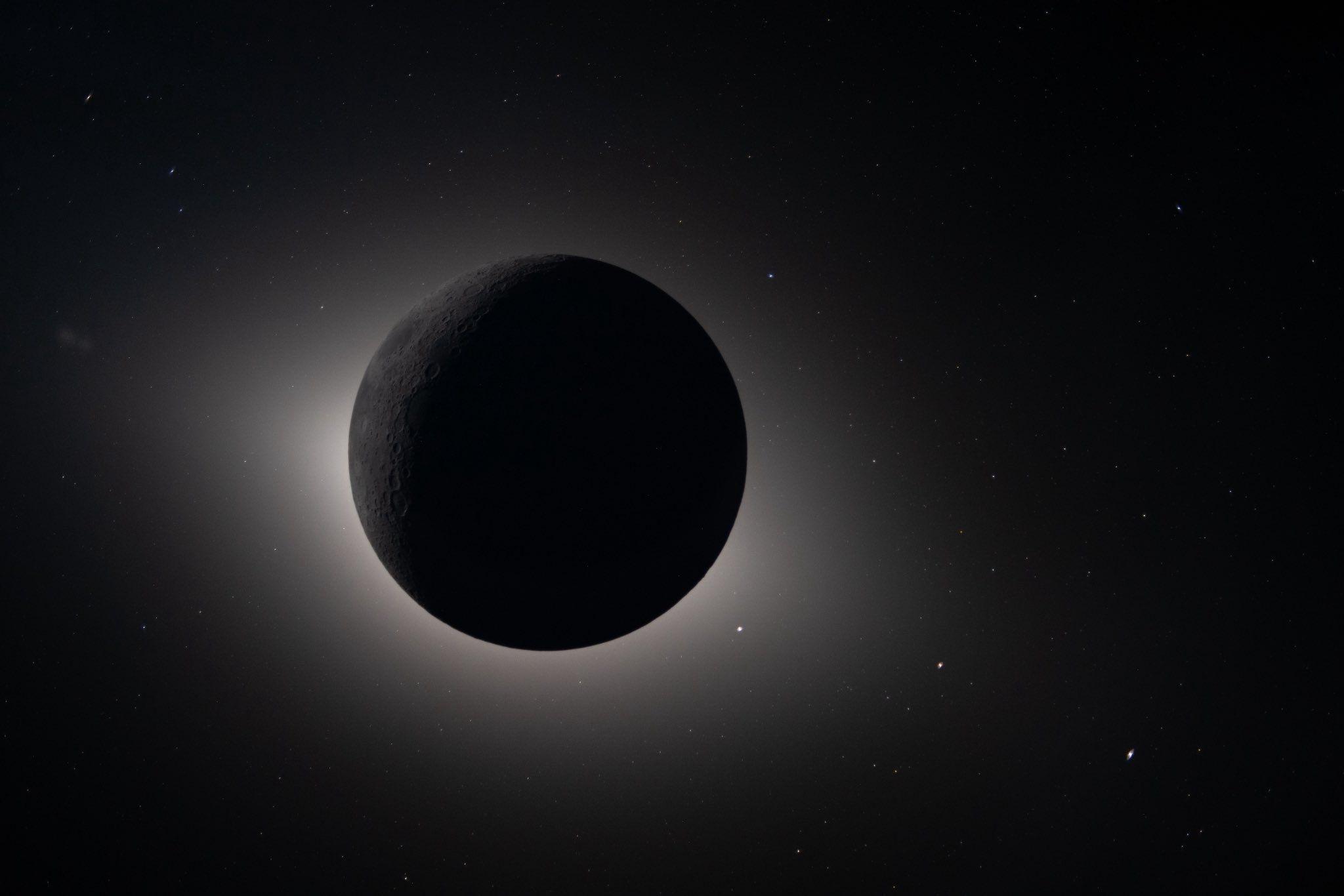 A dark circle in th eblackness of space with the Sun's atmosphere shimmering around its edges.