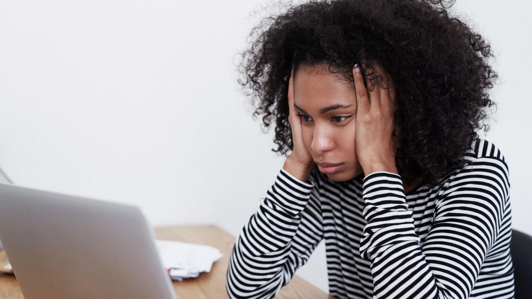 Woman looking frustrated at her laptop