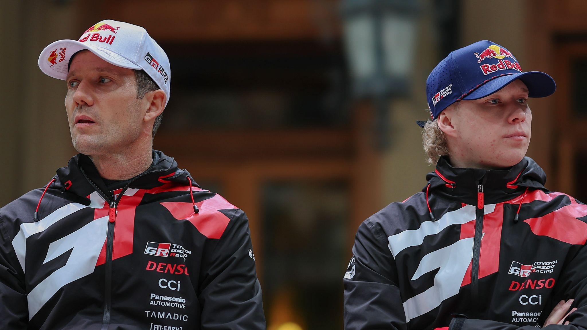 Sebastien Ogier and Kalle Rovanpera look in opposite directions at a joint media conference
