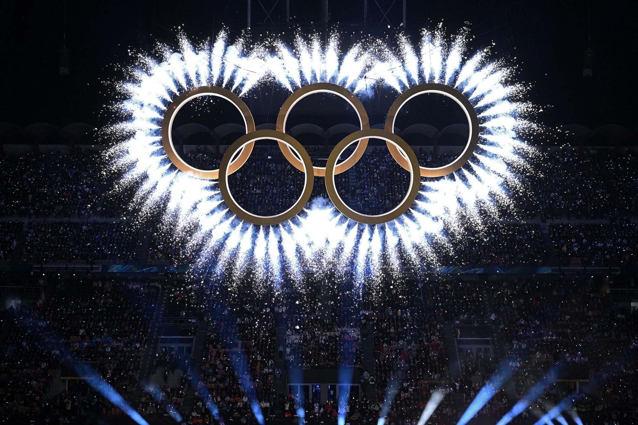 Fireworks burst out of the Olympic rings during the opening ceremony at the San Siro