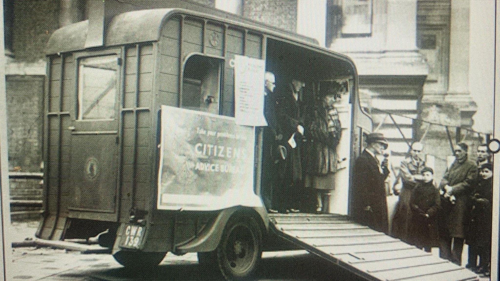 A grainy black and white photo of an old horsebox with a sign outside saying 'Citizens Advice Bureau'.