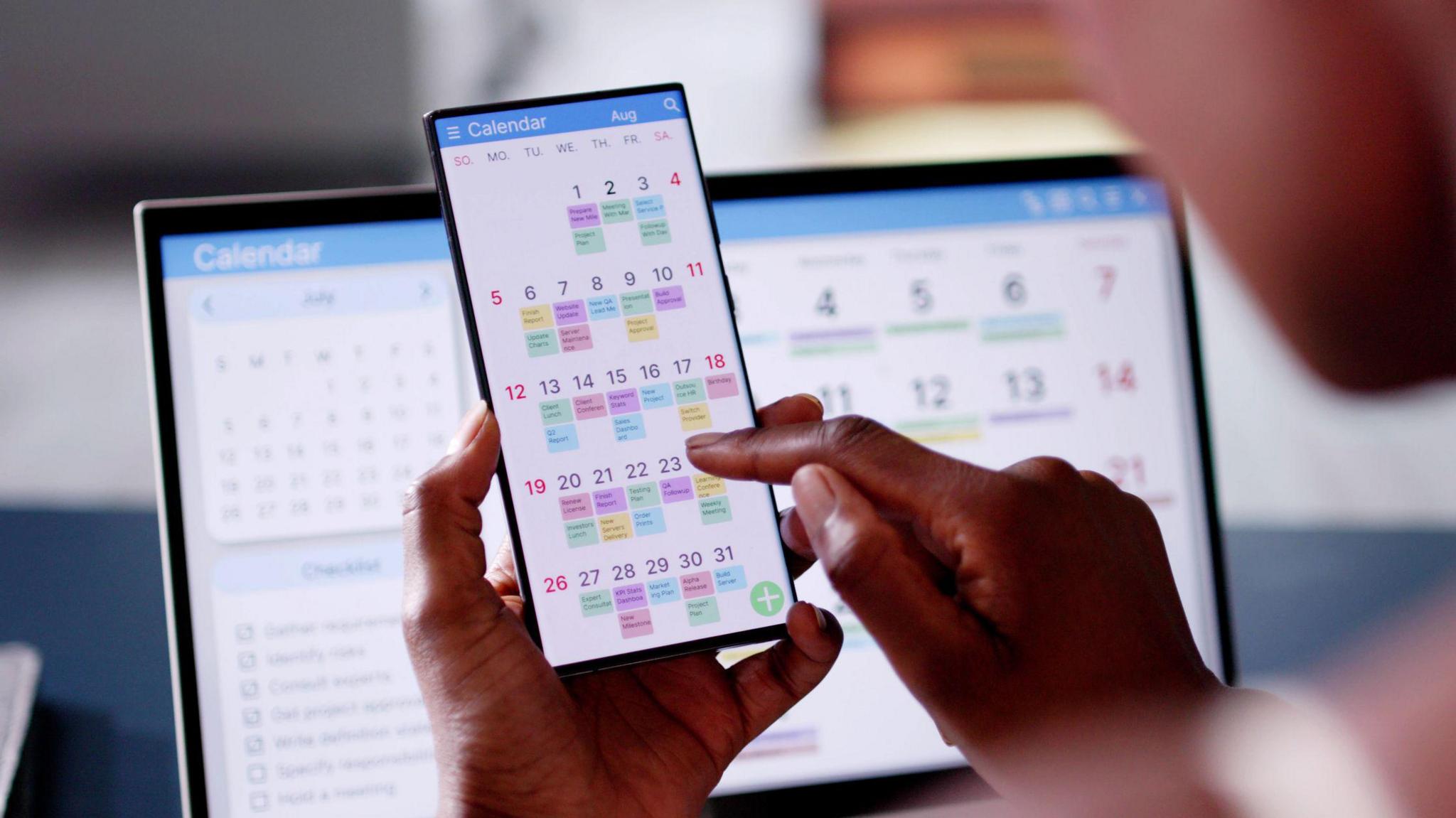 Person looking at a phone calendar which is very busy