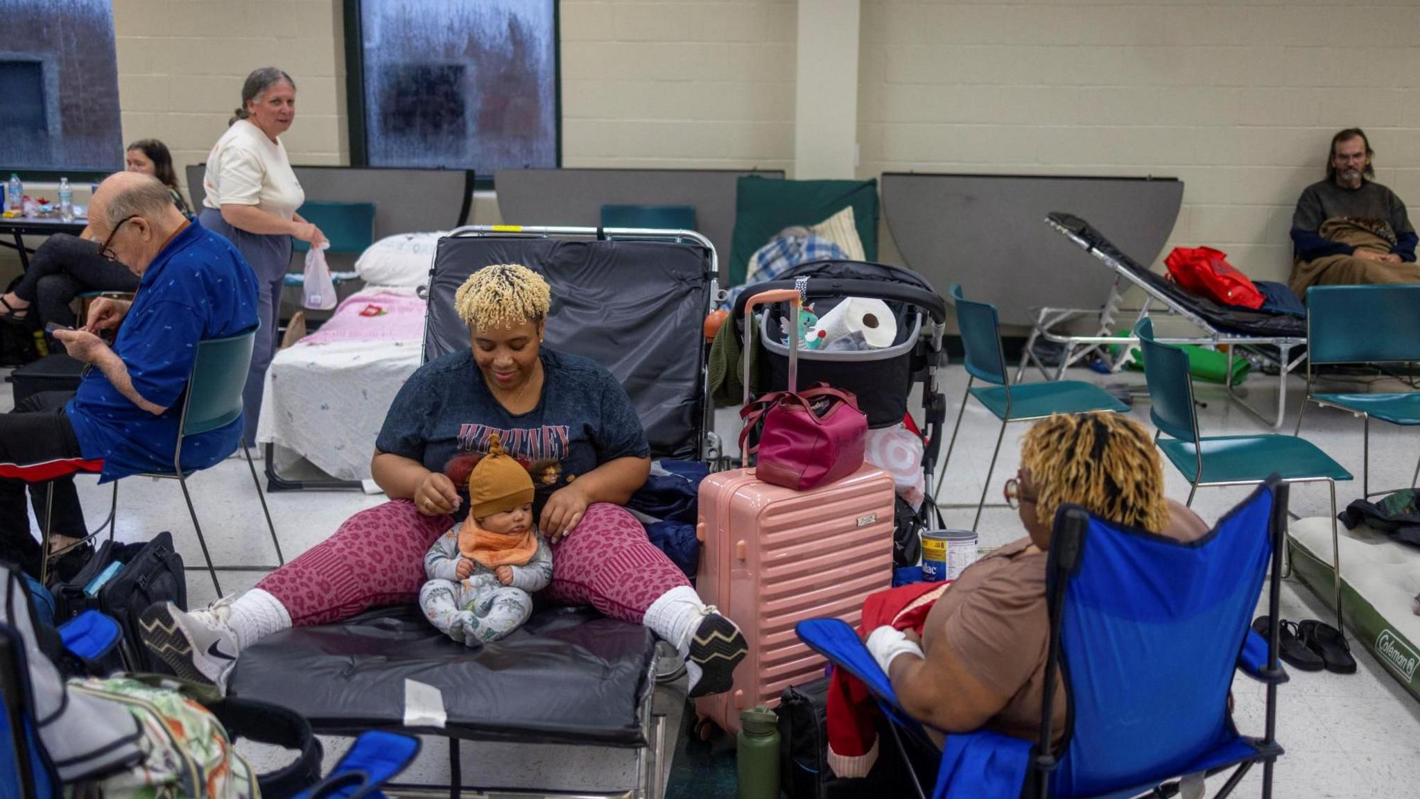 Lindsay Smith, her four-month-old son Maze Crawford, and mother Dieonne Smith, wait for the arrival of Hurricane Helene at Lincoln High School, which was opened as a shelter in Tallahassee, Florida 
