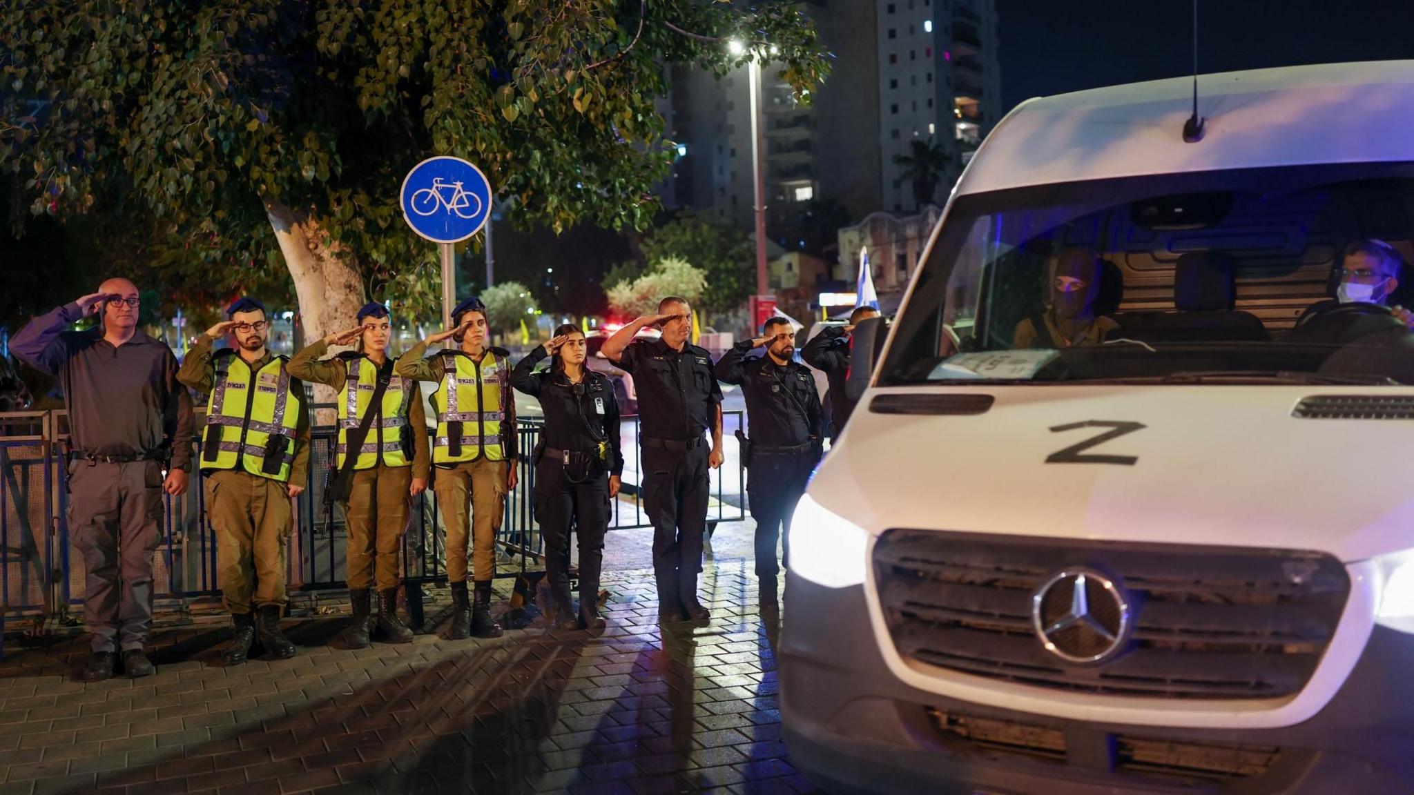 Israeli soldiers and police salute as a convoy carrying the coffin that Hamas said contained the body of an Israeli hostage held in Gaza arrives at the National Centre of Forensic Medicine in Tel Aviv, Israel (28 October 2025)