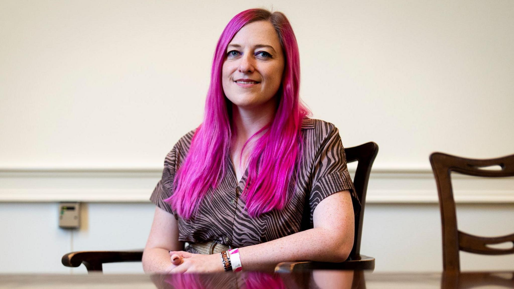 Ally Outten, sitting in a chair, who received an honour for lending prom dresses to struggling families