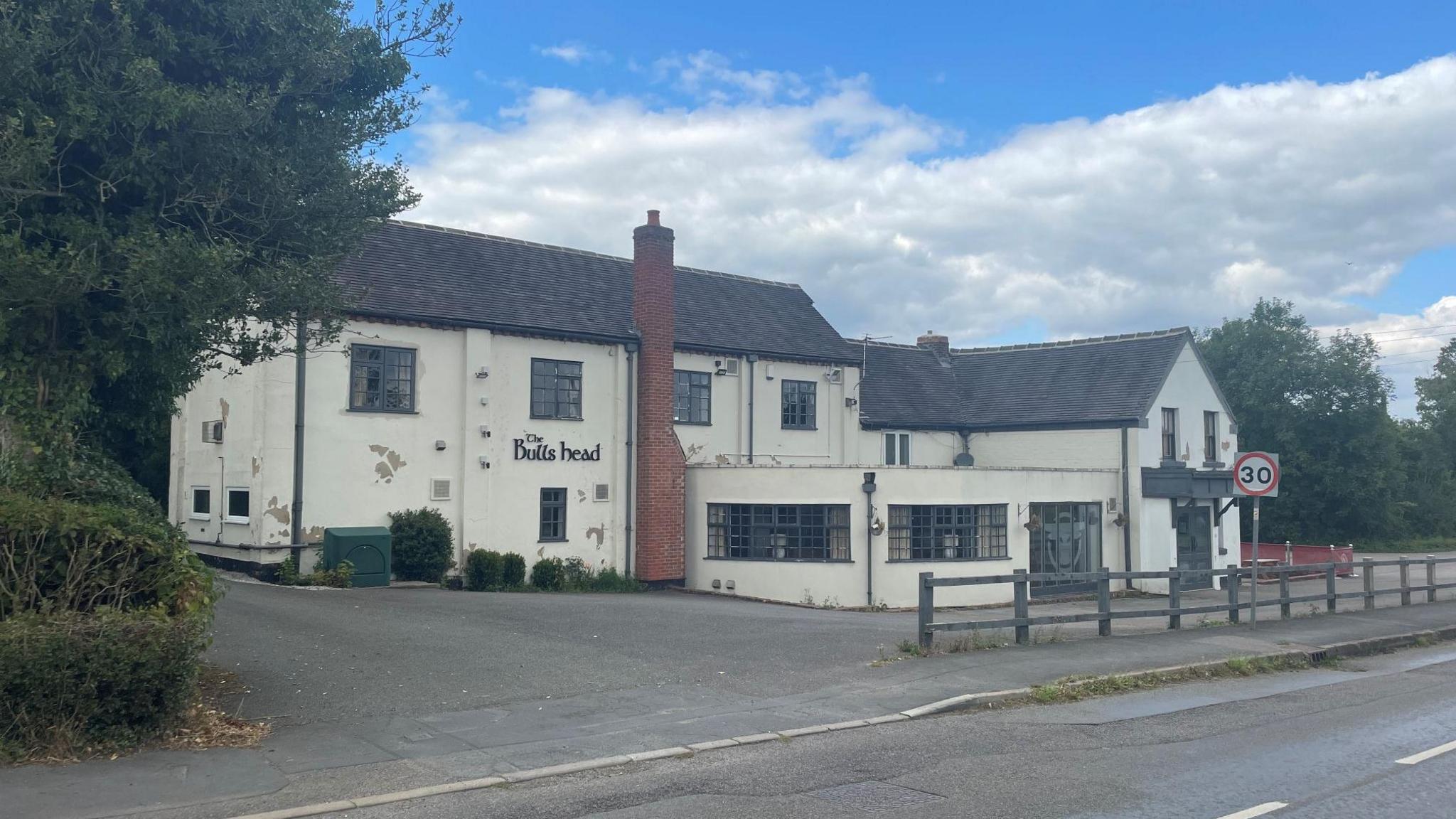 Bulls Head in Denby, on a partially cloudy day with an empty car park.