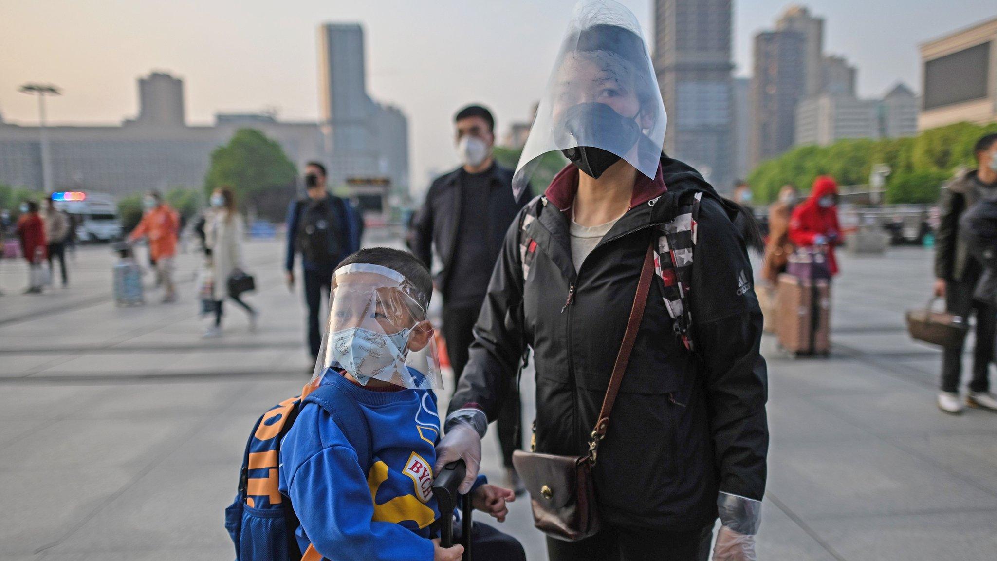 mother-and-son-wearing-masks-prepare-to-leave-wuhan