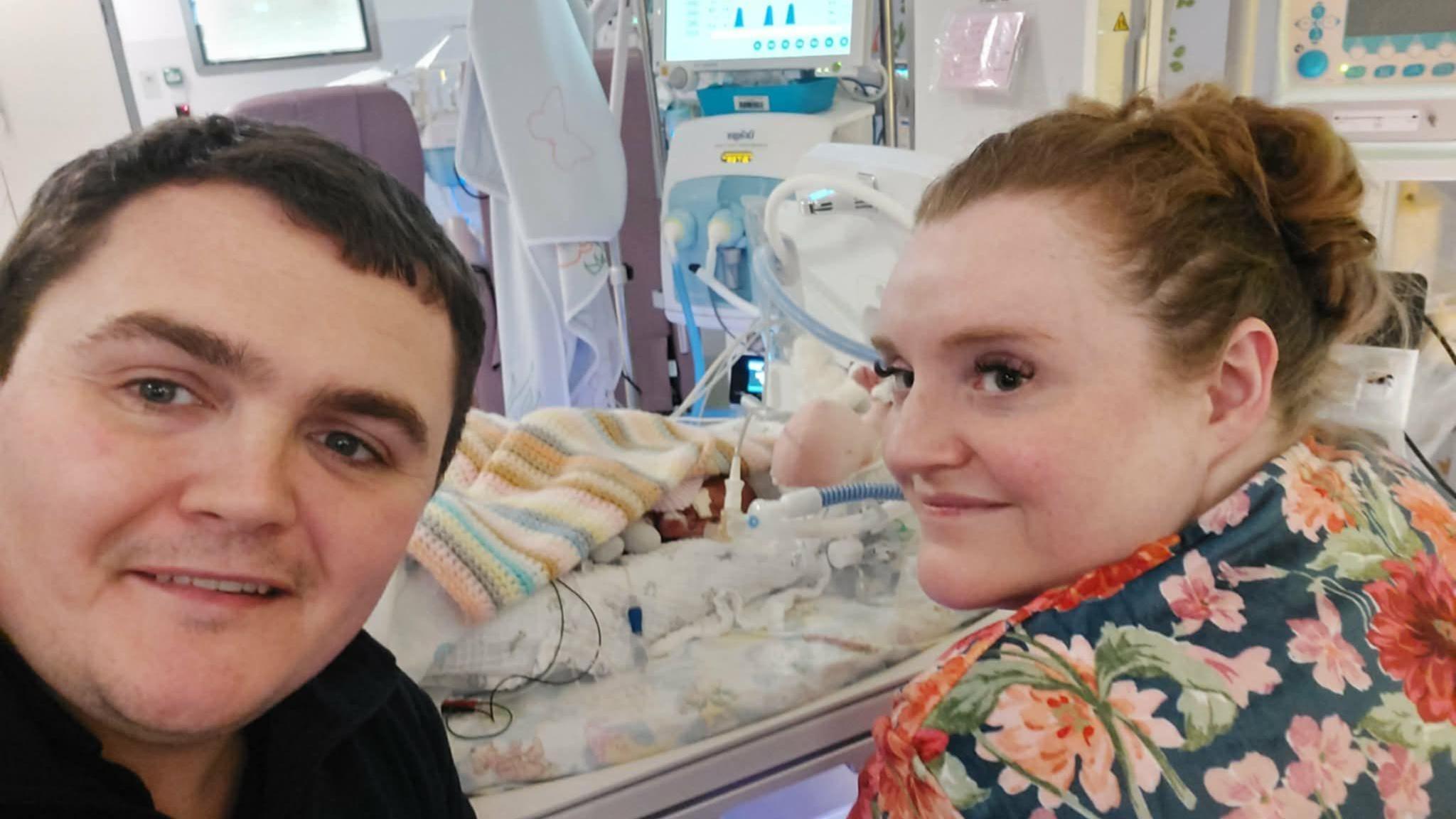 Rhieni Arwen wrth ei chrud wrth iddi gael triniaeth ysbyty ar ôl cael ei geni mor gynnar