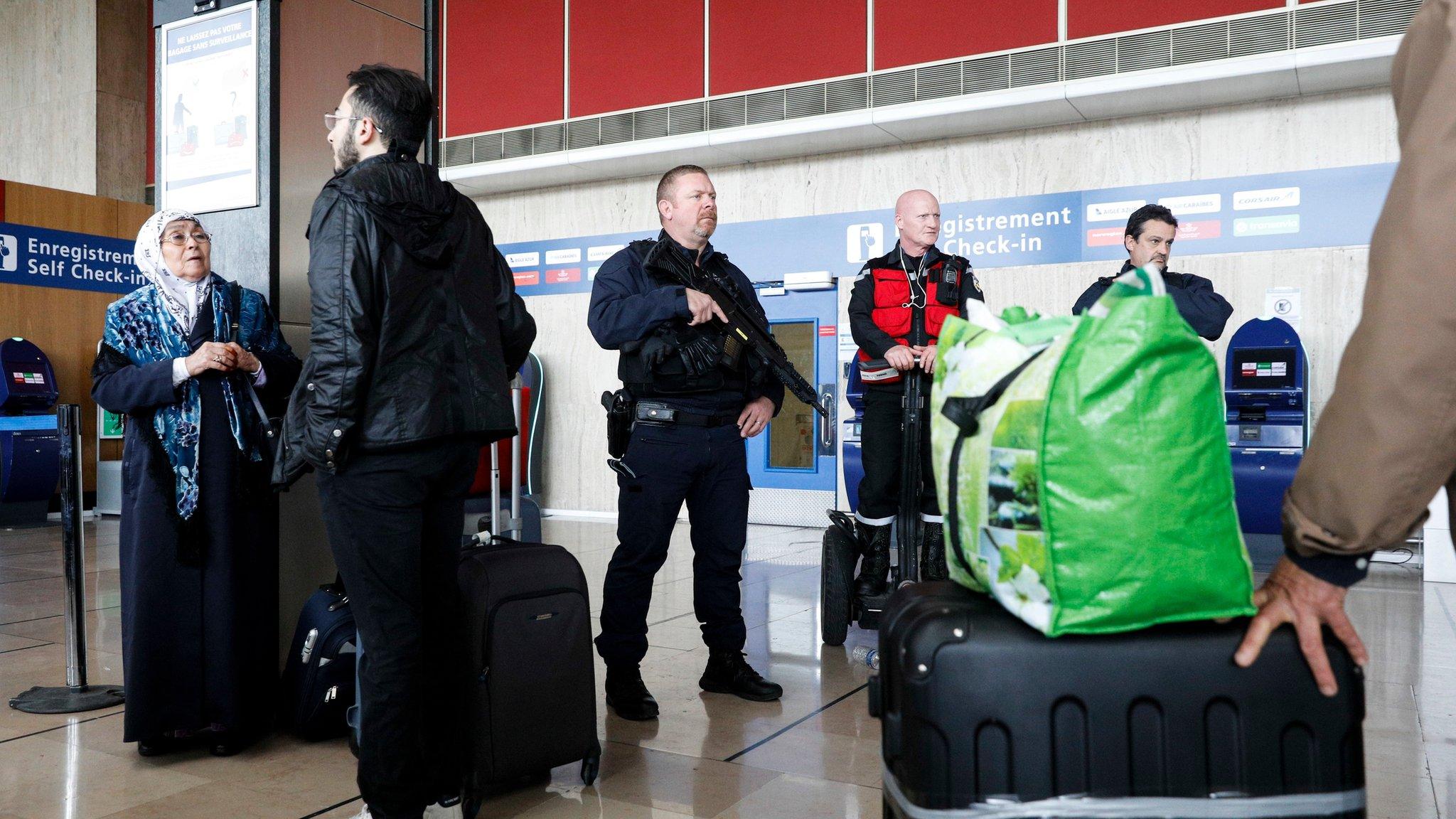 A riot police officer patrols inside Orly airport after the resumption of flights on 18 March