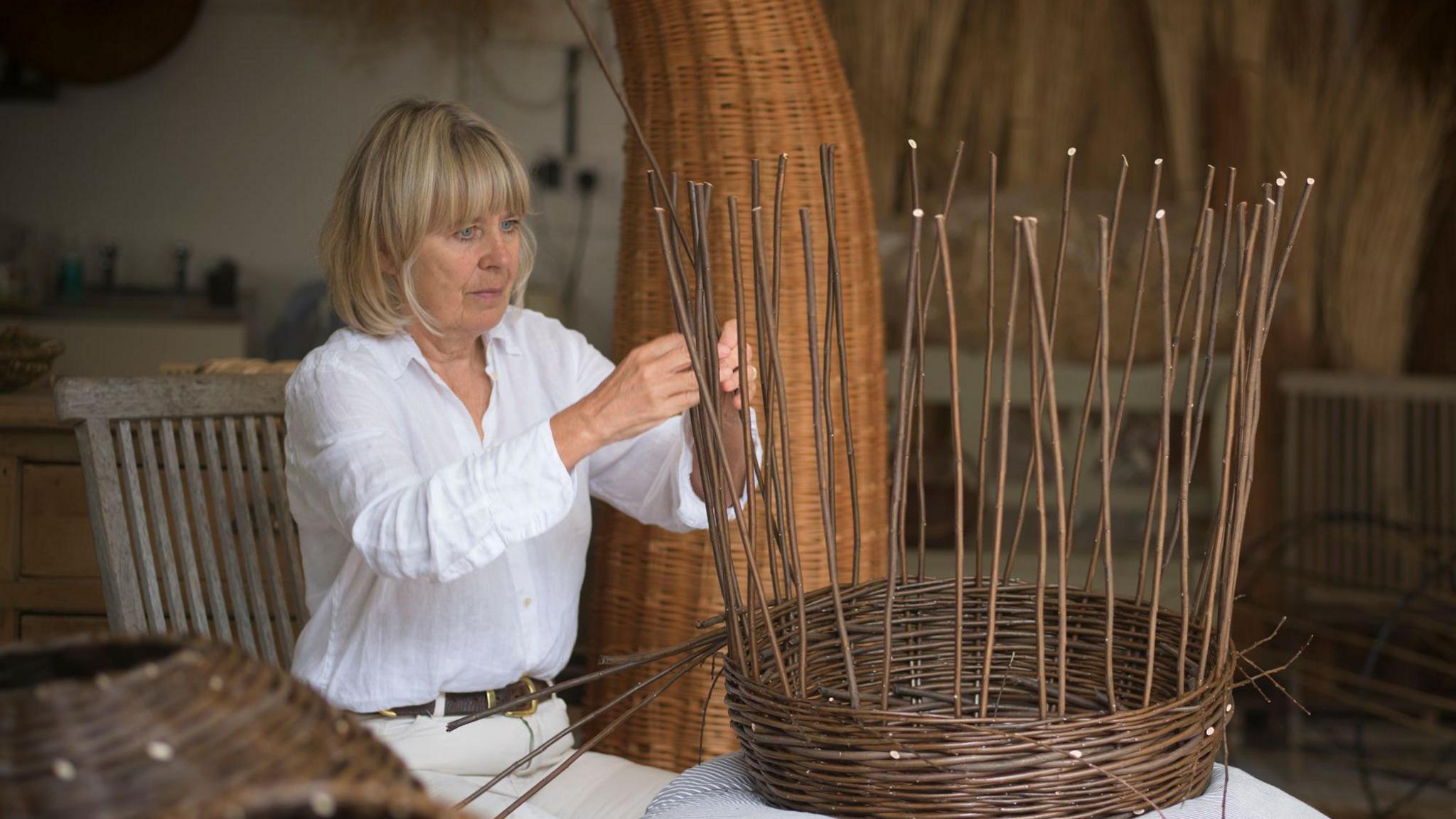 Angela Palmer creating one of the pieces. She is weaving bits of willow together to form a vertical structure