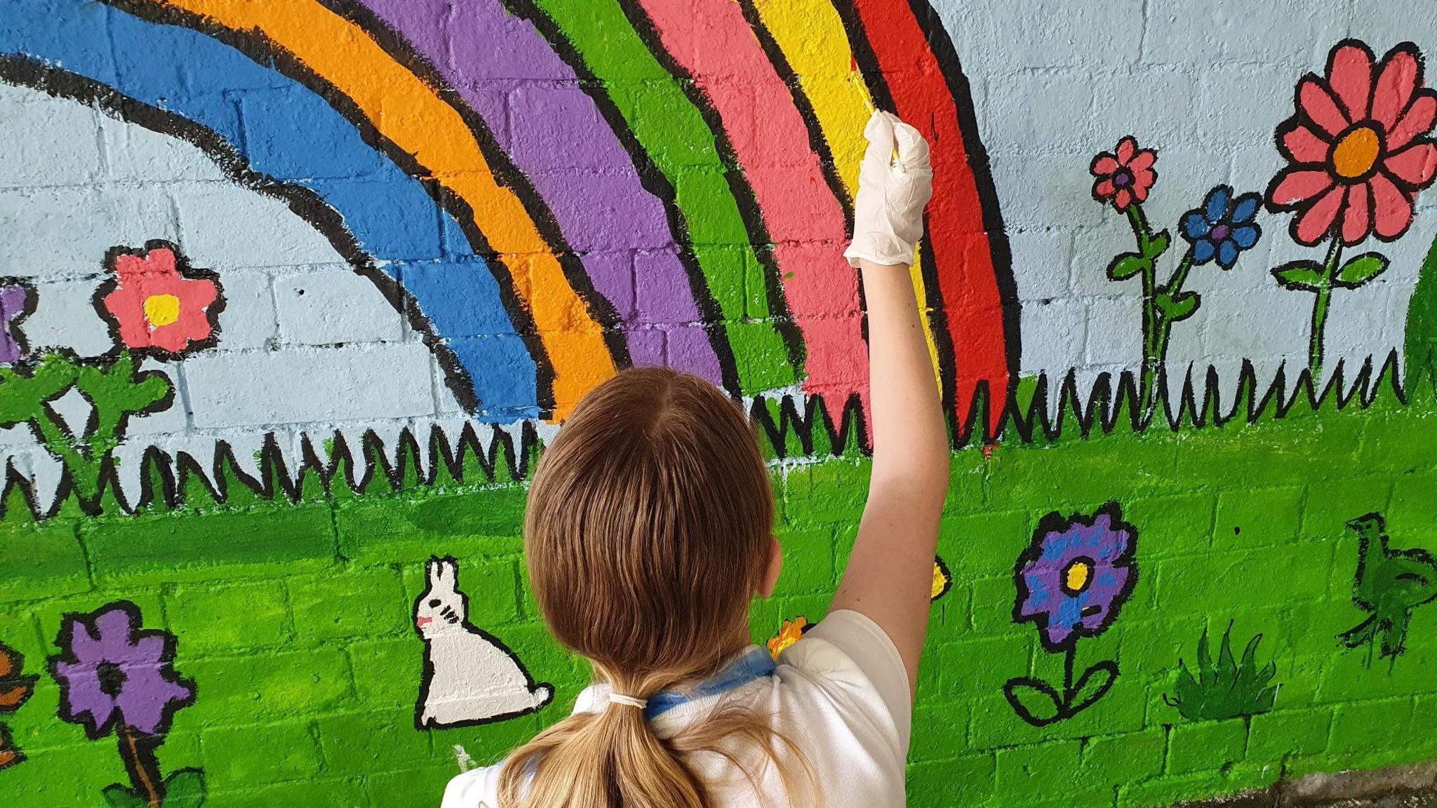 Child painting a rainbow