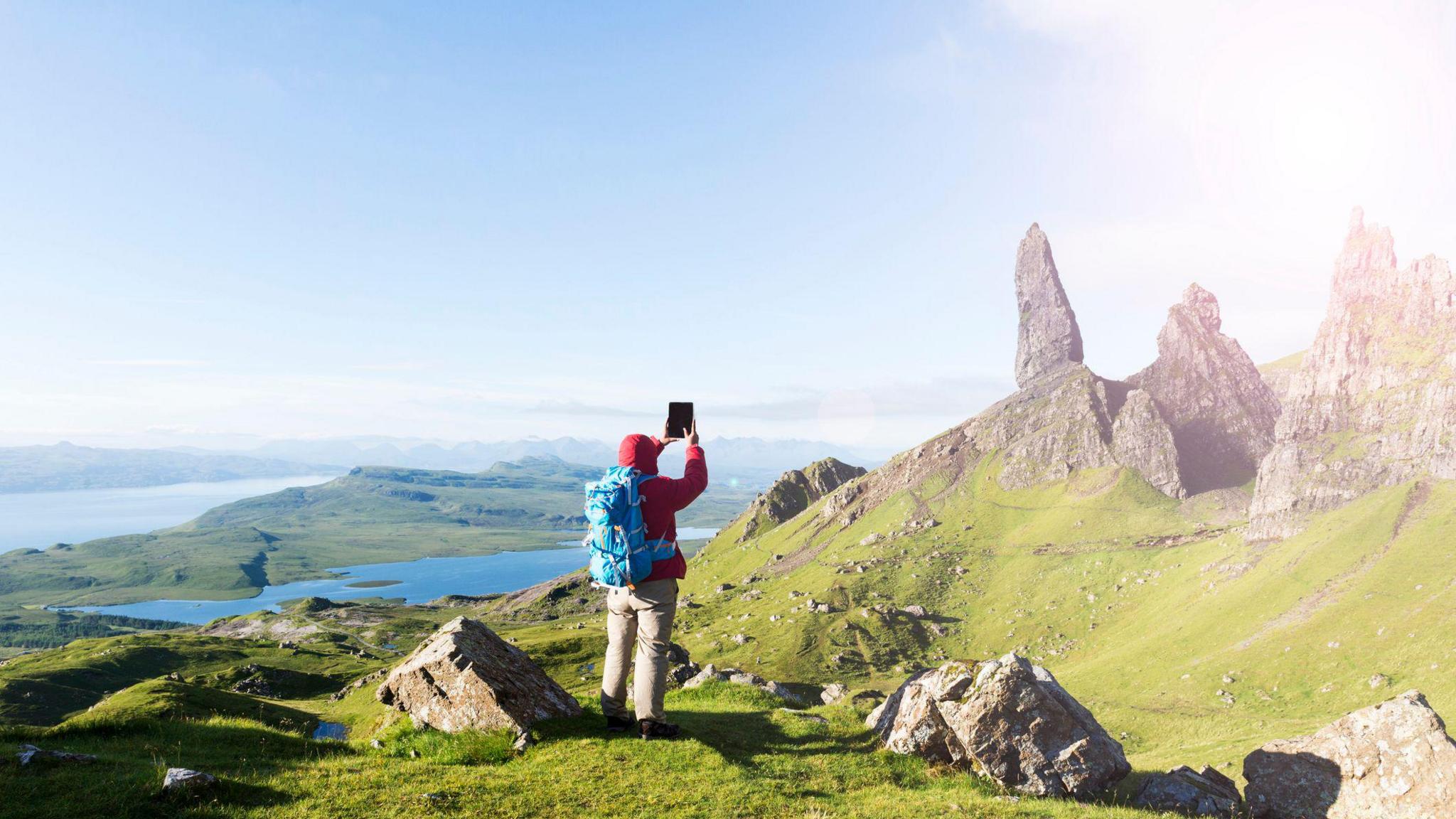 Dealbh de neach-turais a' togail dhealbh de Bhodach an Stòirr