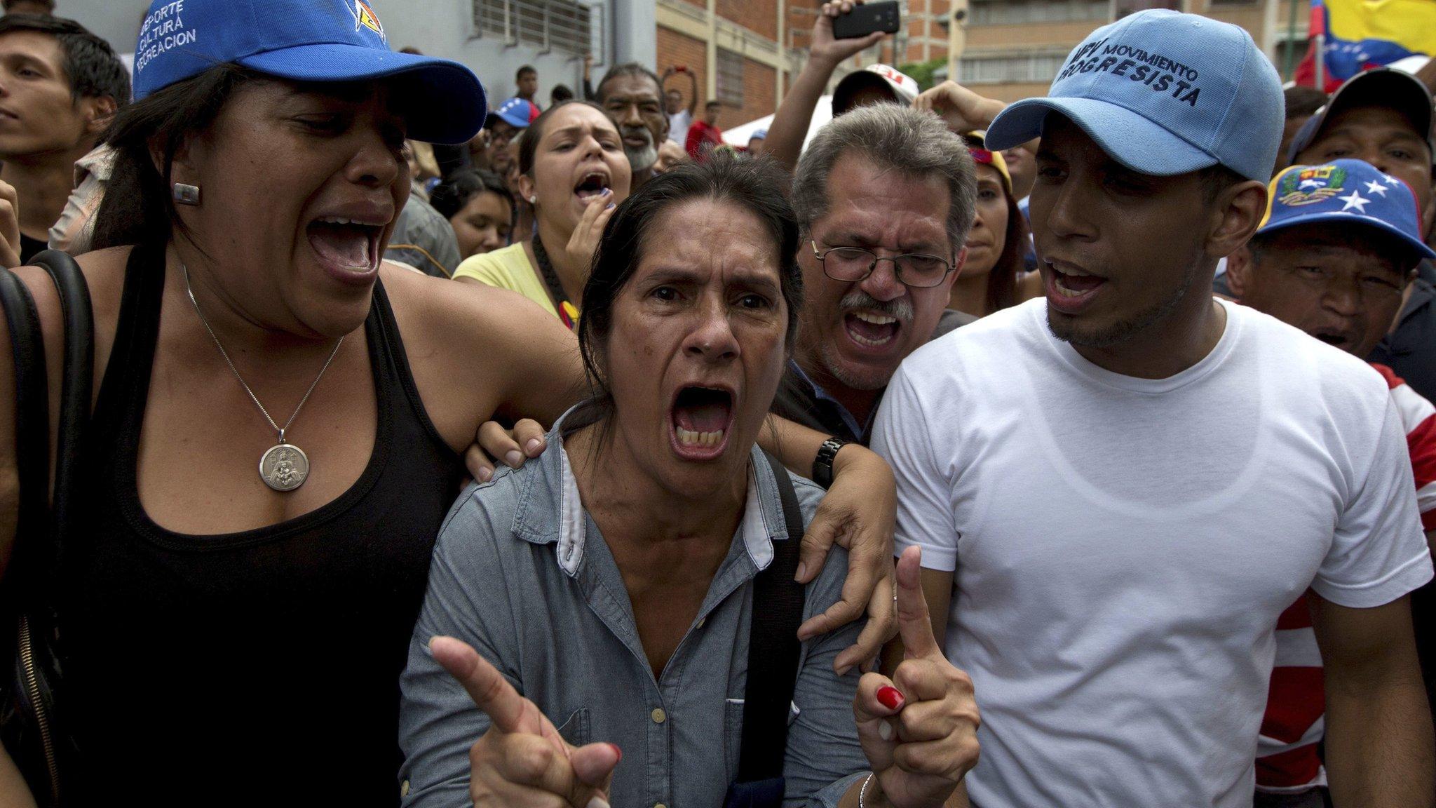 A woman standing outside validation centre to certify her signature becomes angry after learning that it closed at appointed hour, without attending those still waiting, in Caracas, Venezuela, Friday, June 24, 2016