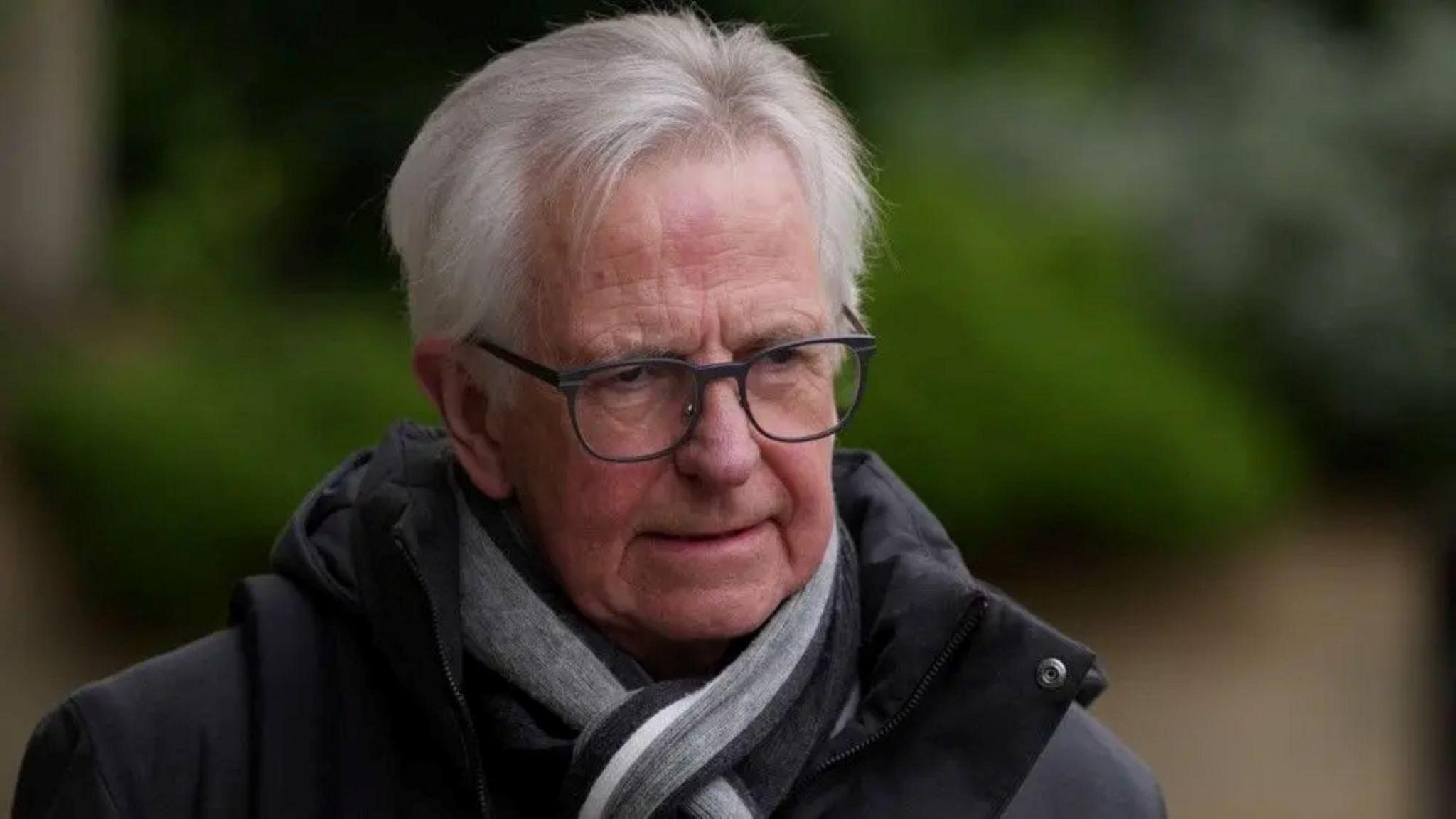 Lord Bracadale pictured in April 2024. He is wearing a grey jacket and scarf and has glasses.