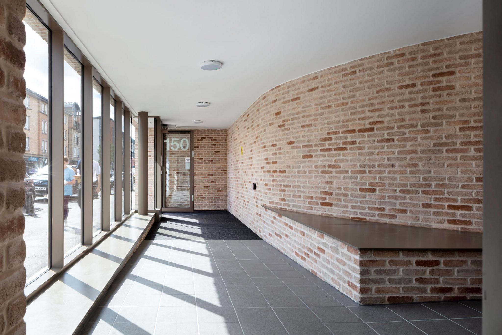 Interior corridor again with big wall-length windows and light coloured brick 