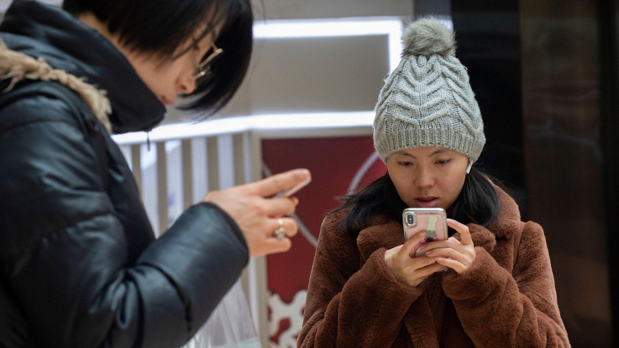 Two woman looking at their smartphones