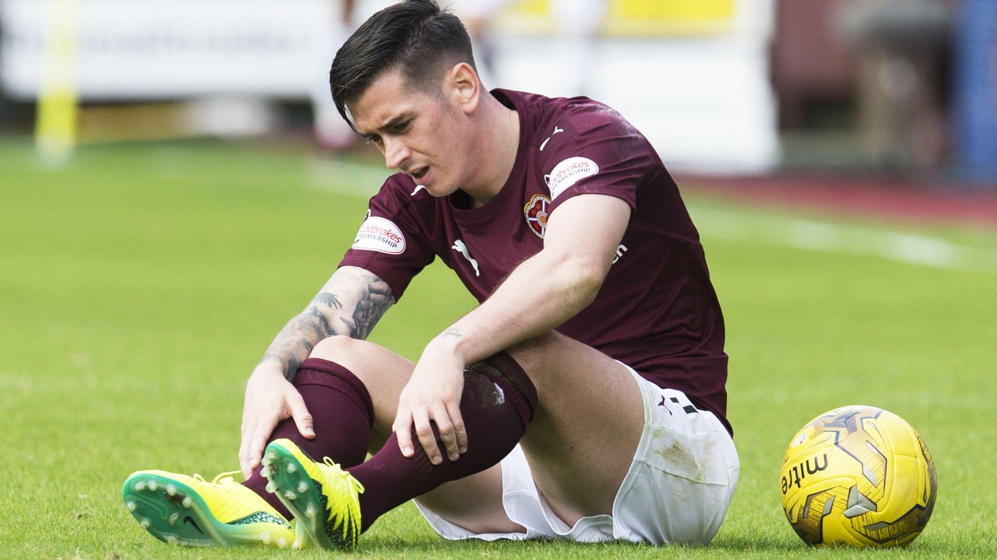 Jamie Walker holds his leg after being awarded the penalty from which Hearts equalised