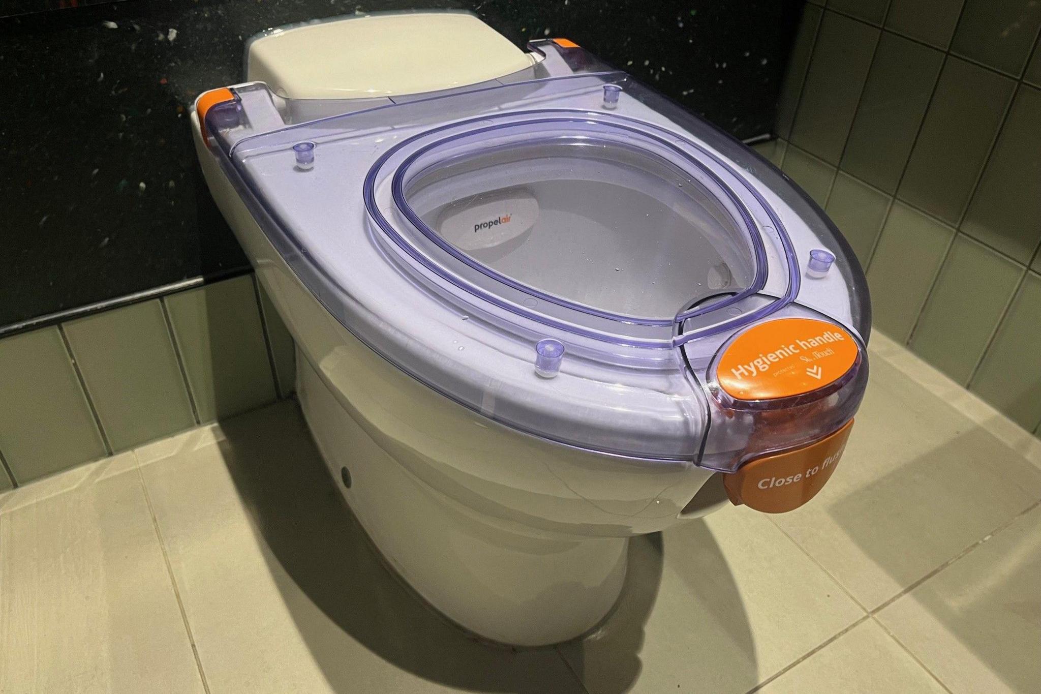 Propelair toilet with transparent purple lid and orange lock on it