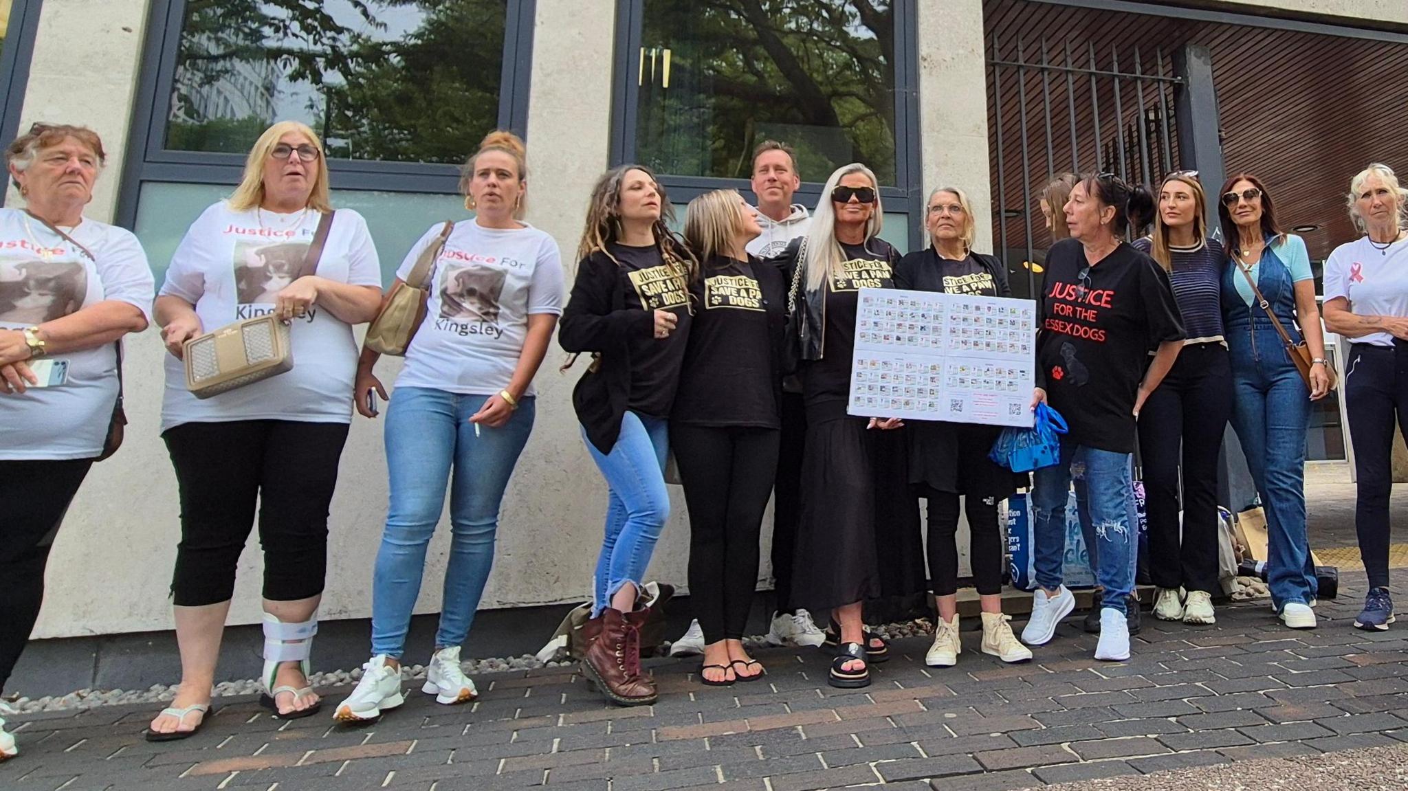 A group of 13 people standing outside Southend Crown Court. They say they are campaigning for justice for the dogs. One is holding a white placard.