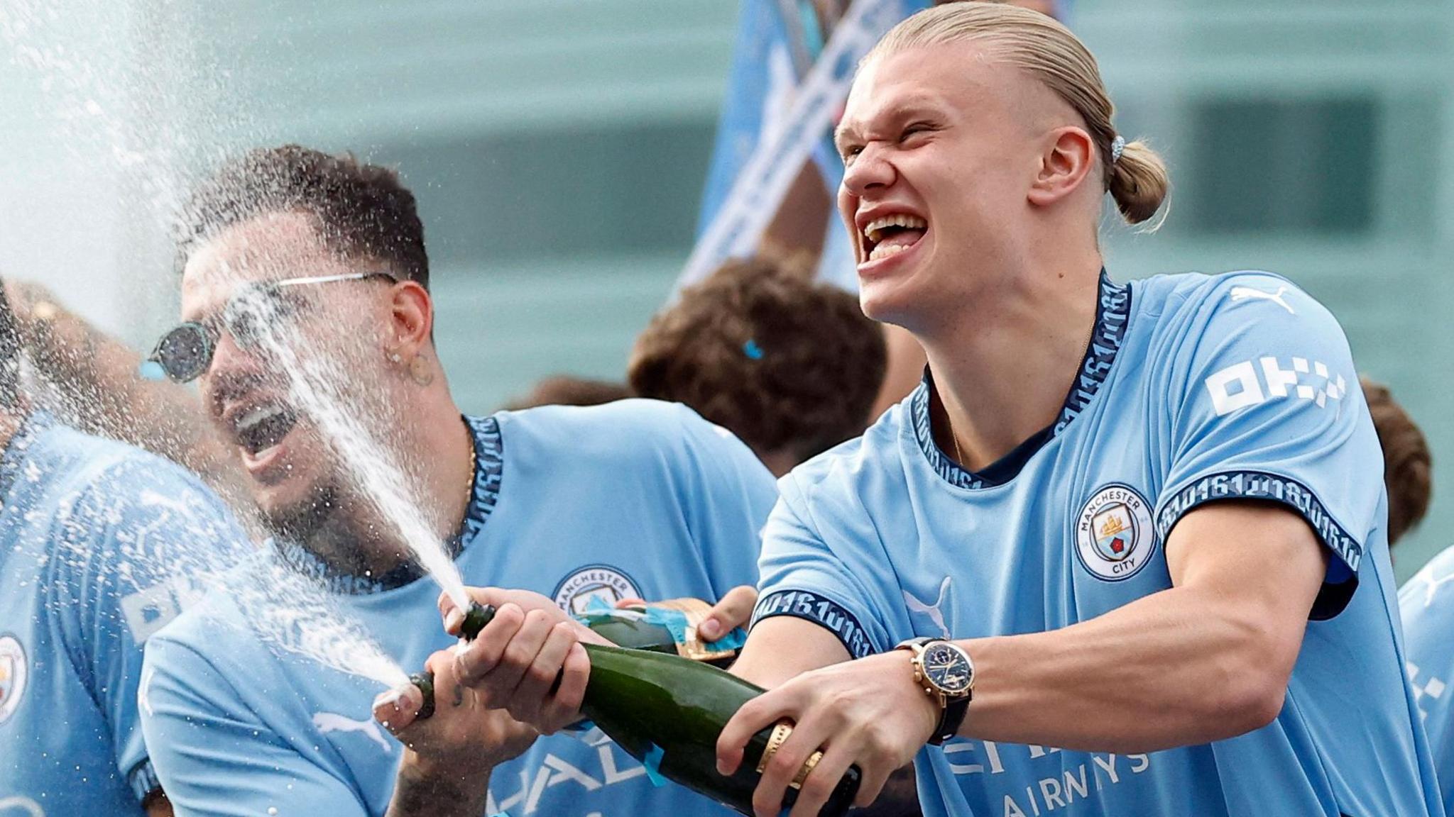 Ederson and Erling Haaland celebrate with champagne