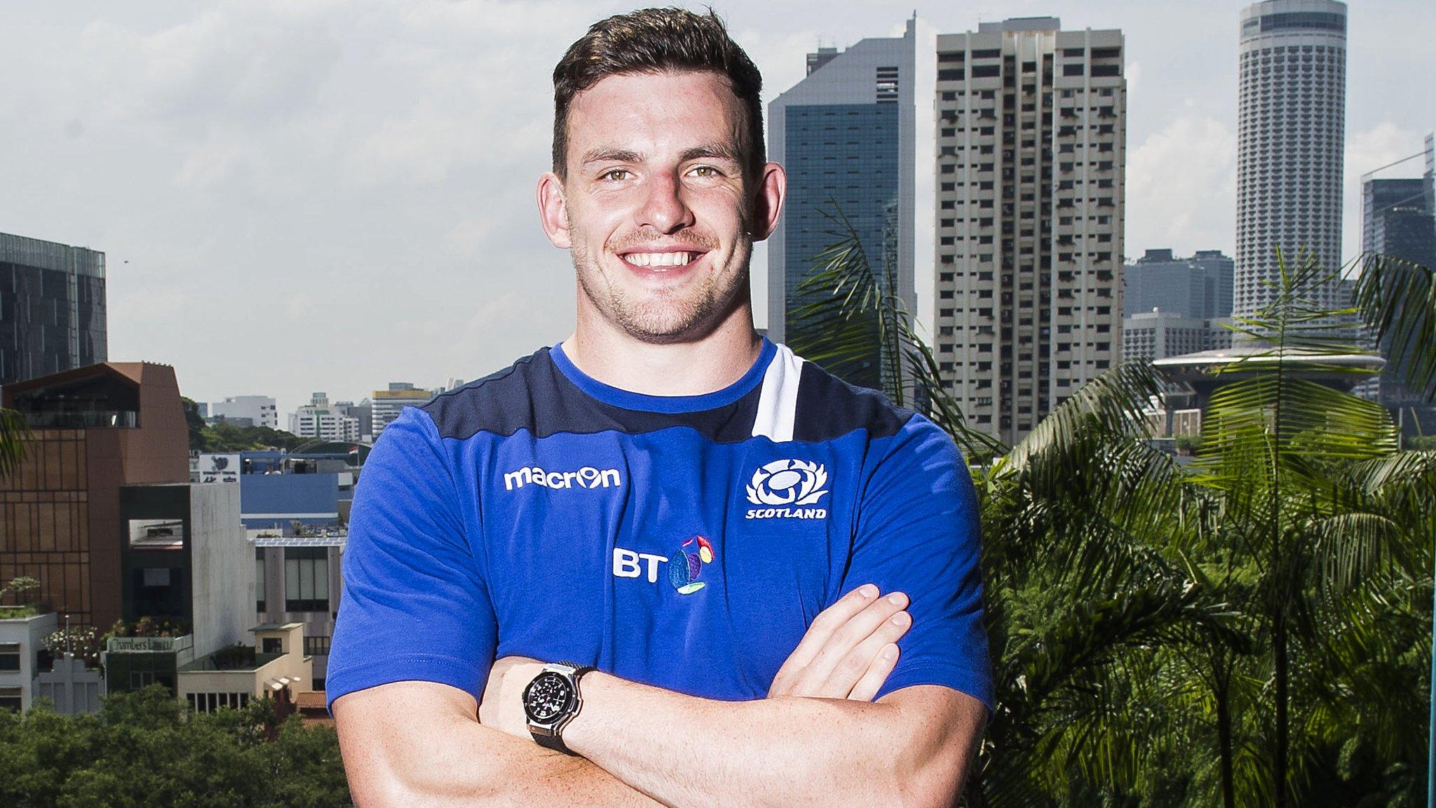 Matt Scott poses for pictures in front of a backdrop of Singapore skyscrapers