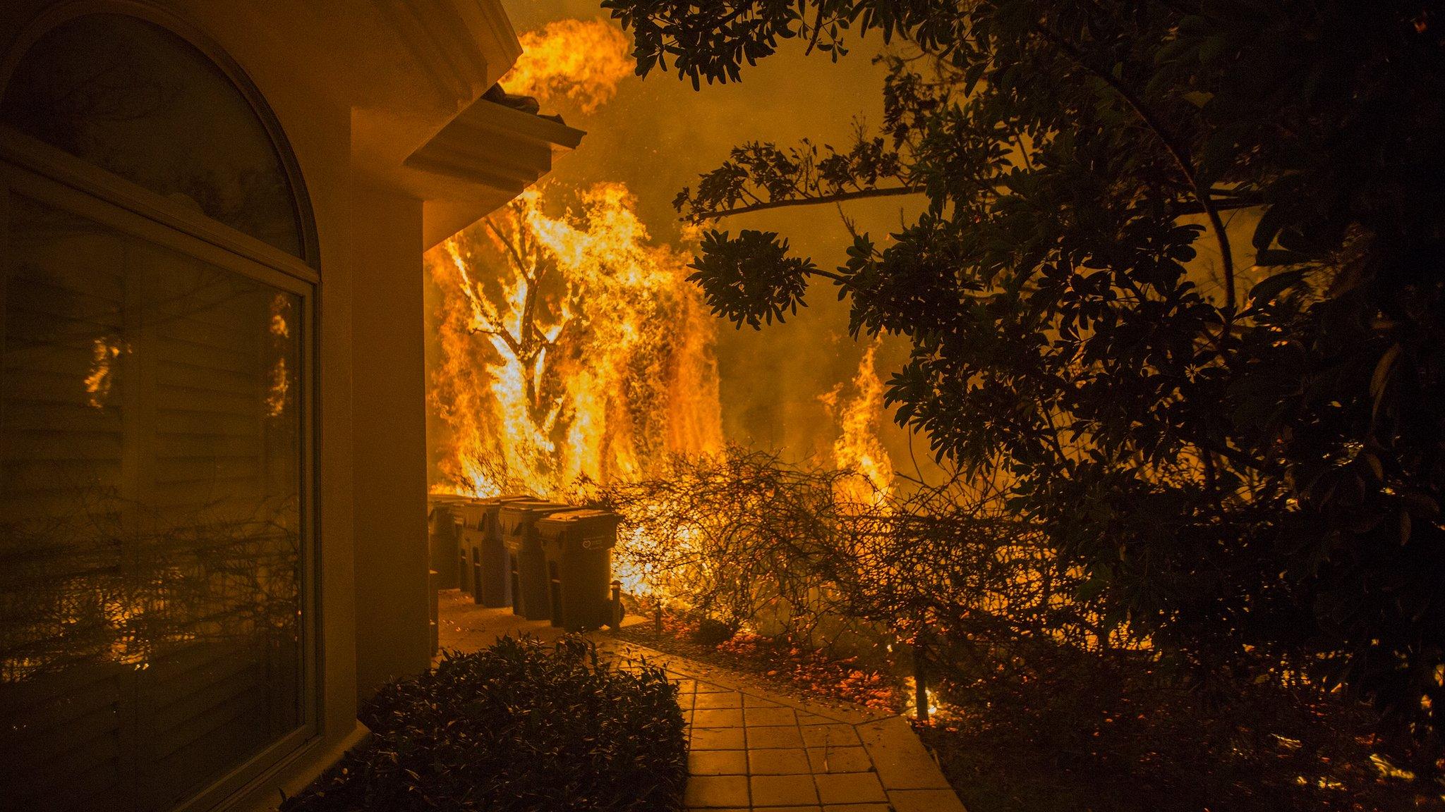 Flames approach a house during the Woolsey Fire on November 9, 2018 in Malibu, California