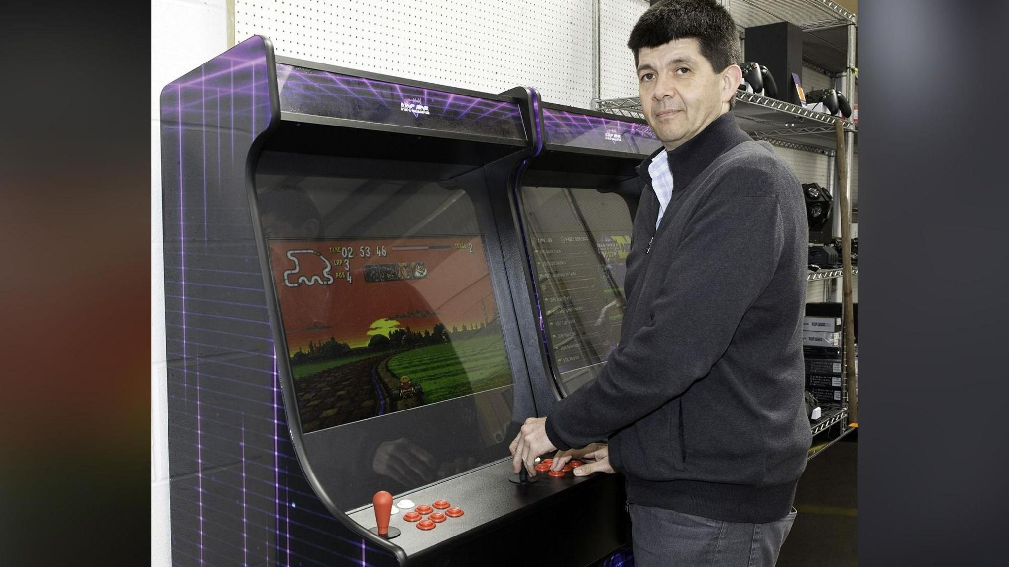 Auctioneer Paul Cooper plays one of the arcade machines up for auction