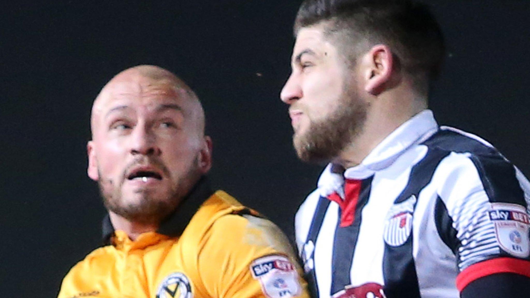 David Pipe of Newport County and Danny Andrew of Grimsby go up for the ball