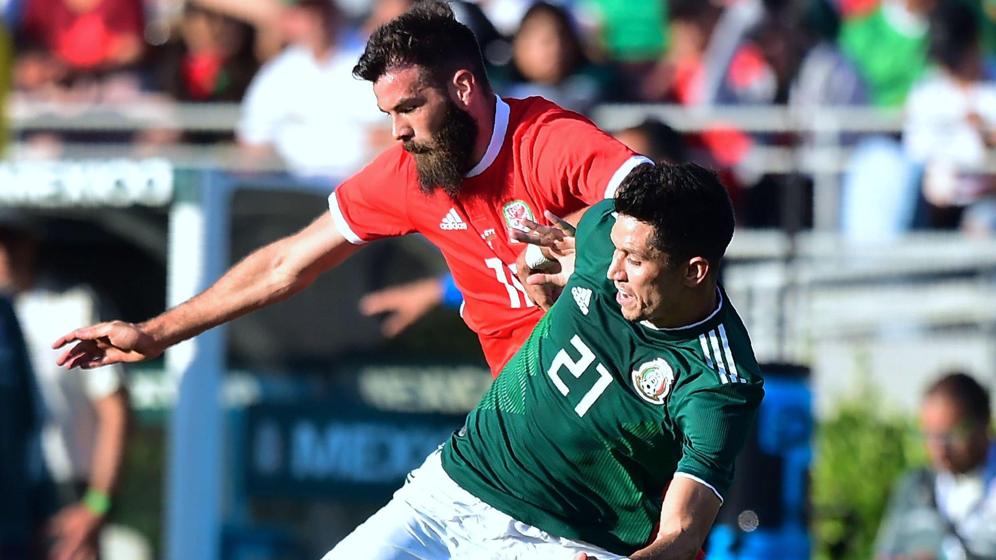 Jesus Molina of Mexico (#21/R) vies for the ball with Joe Ledley of Wales