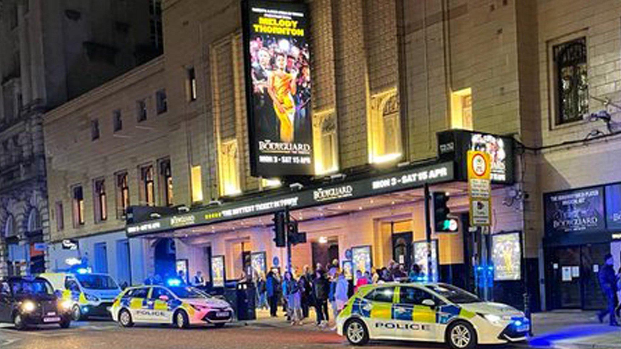 Exterior of Manchester's Palace Theatre with two poliec cars pulled up outside.