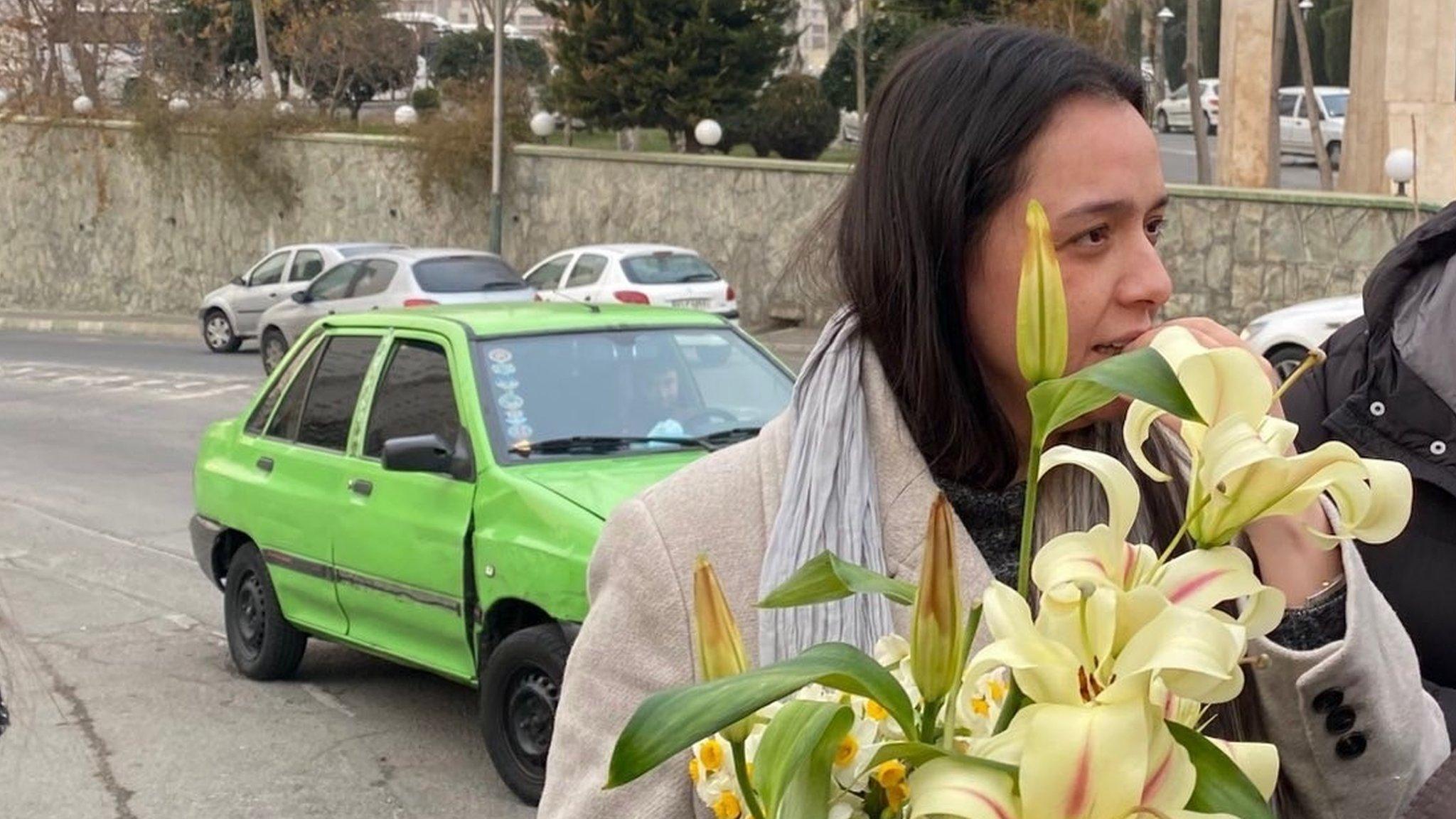 Iranian actress Taraneh Alidoosti holds a bouquet of flowers outside Tehran's Evin prison after being released on bail (4 January 2023)