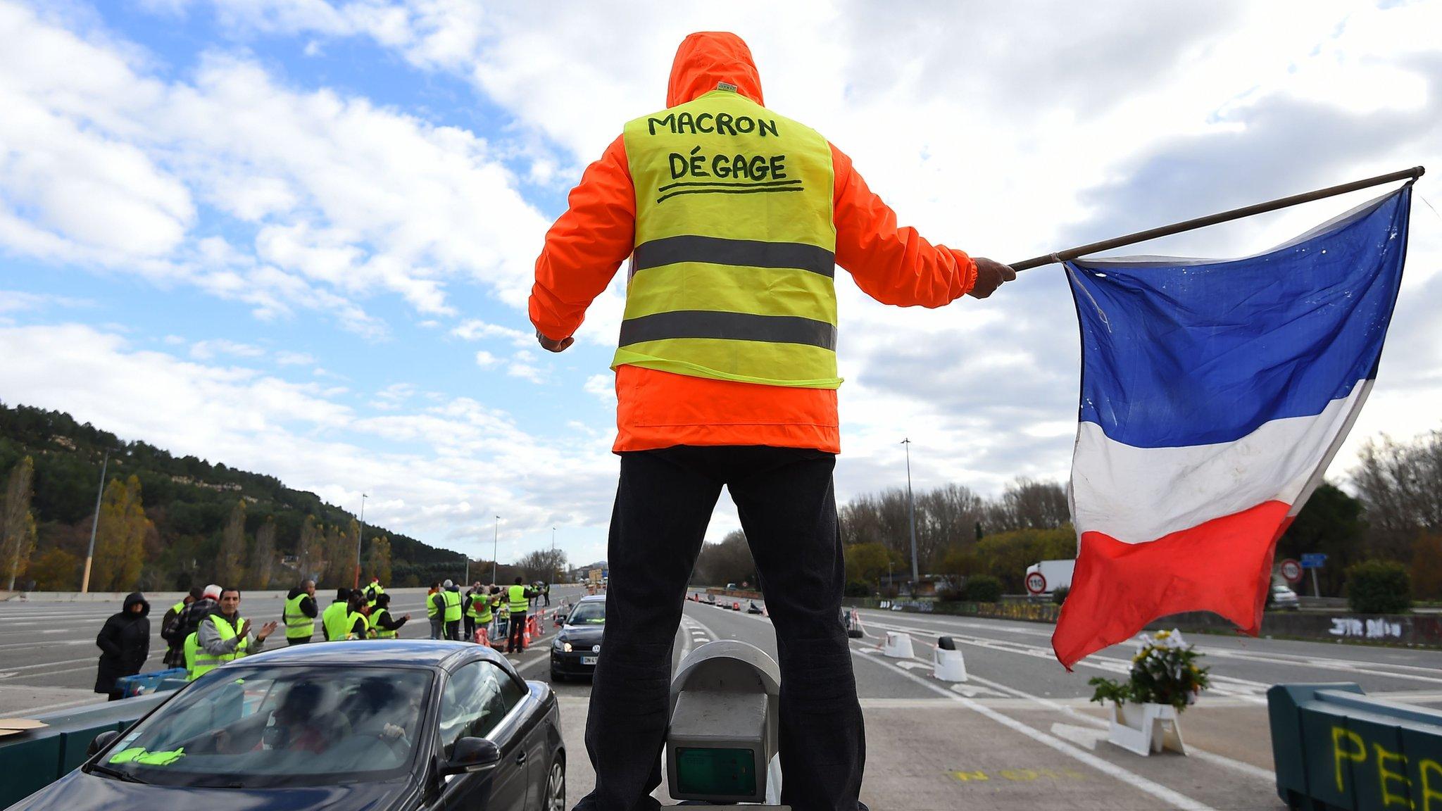 Yellow vest protester in France waving a French flag