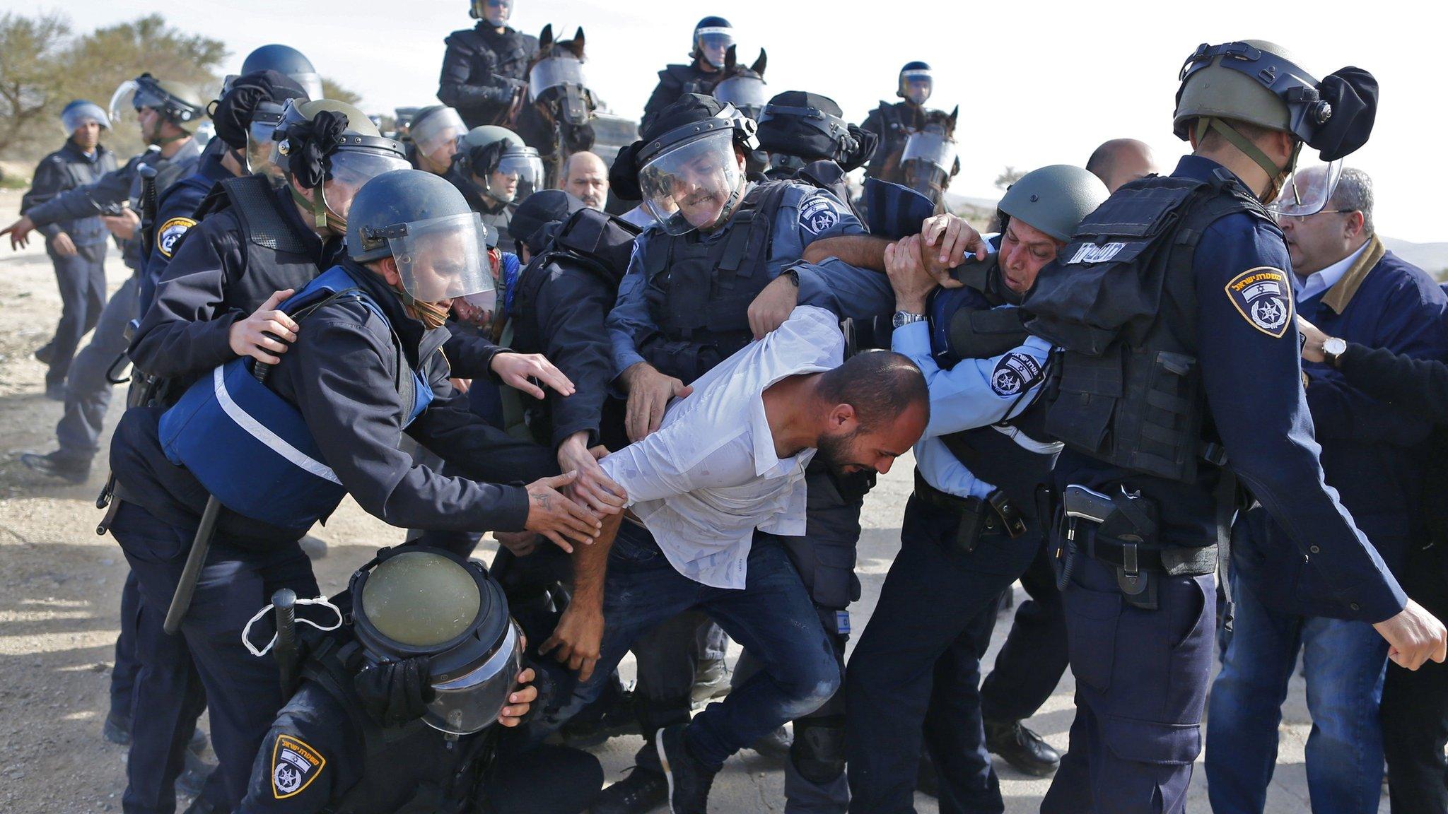 Israeli policemen detain a Bedouin man during a confrontation over home demolitions in the Bedouin village of Umm al-Hiran (18 January 2017)