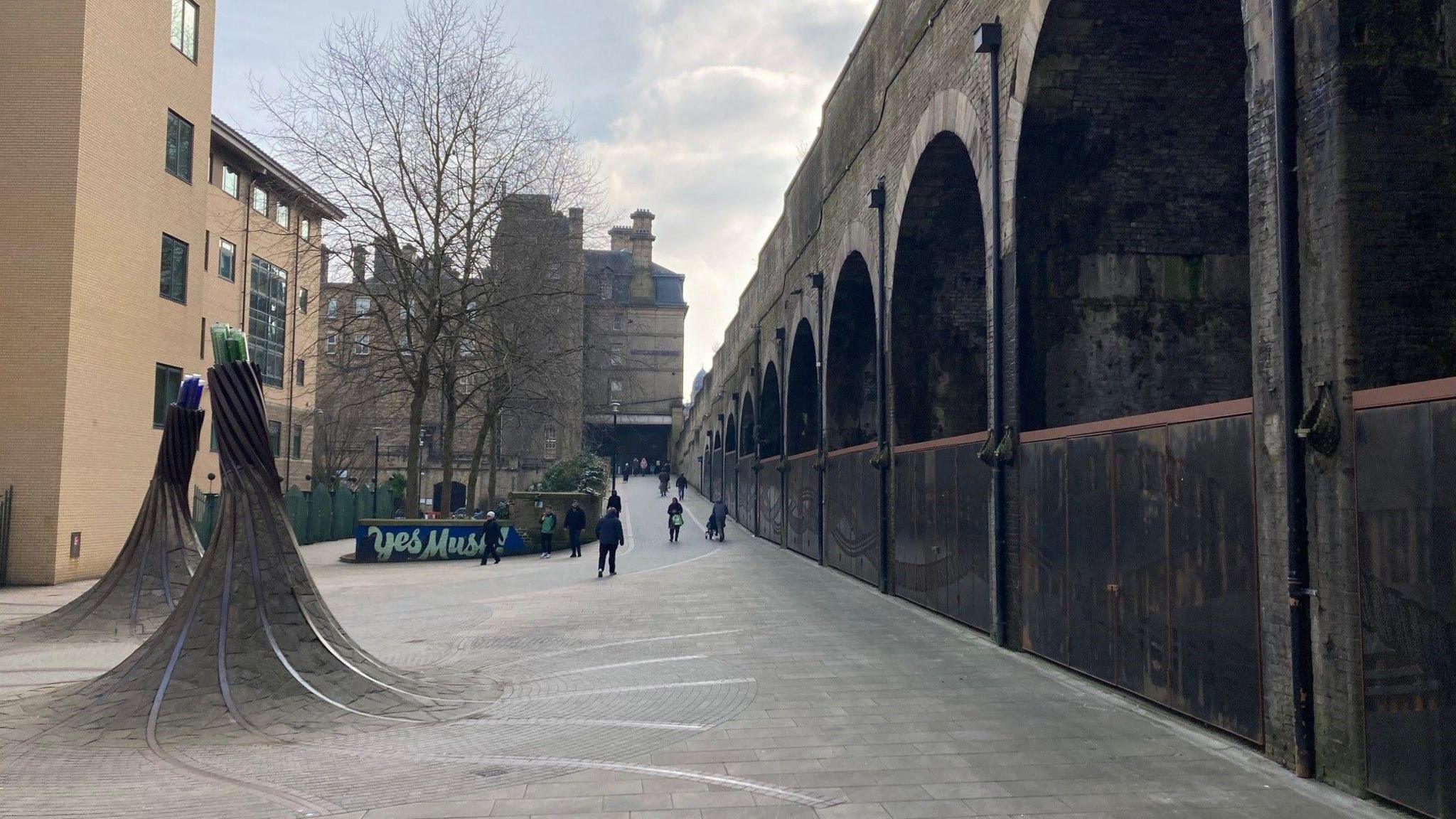 A sculpture on the left in Forster Square and on the right the metal gates inside the archways.