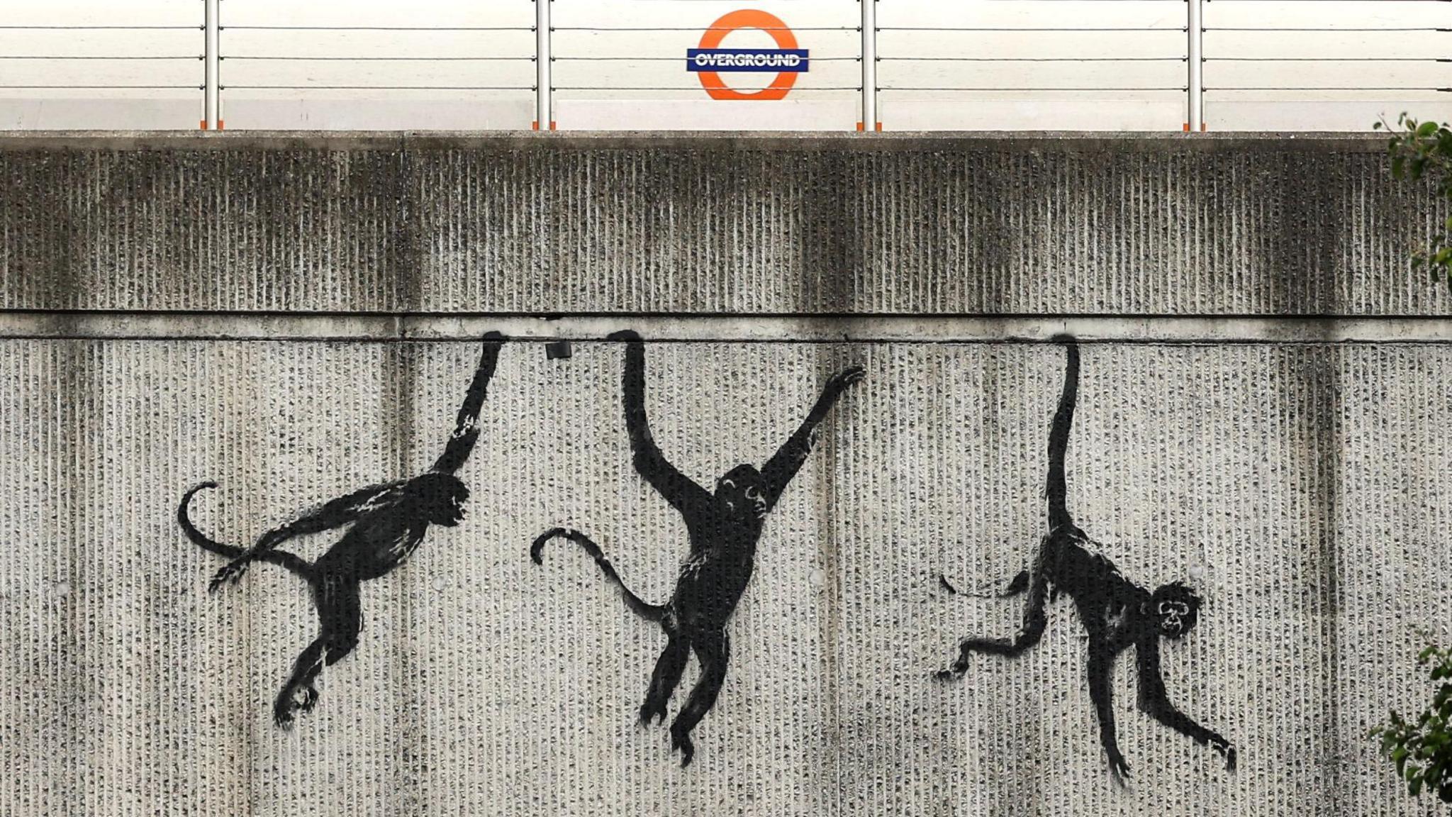 Three monkeys painted on a railway bridge in London