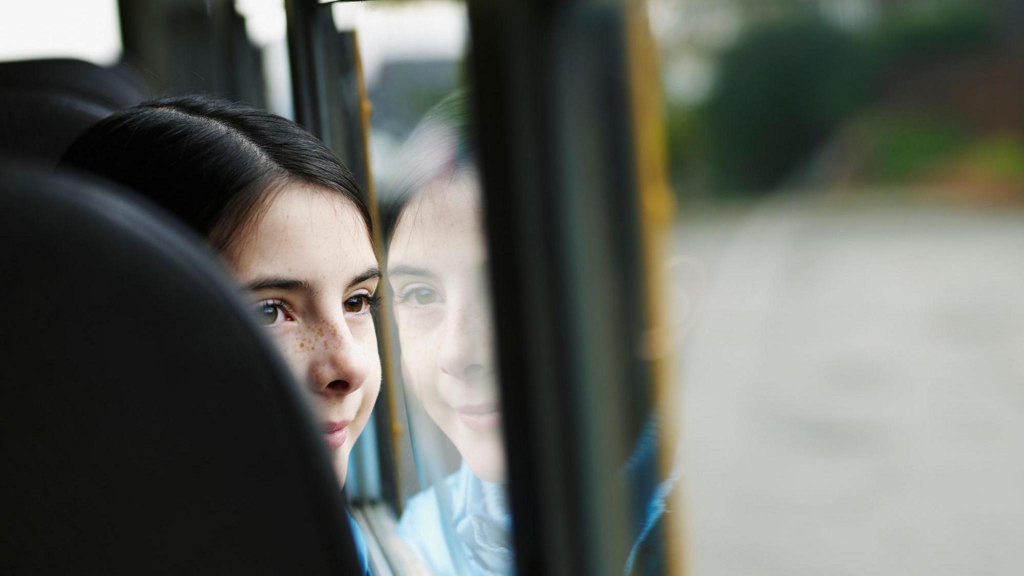 A stock image sat on a bus looking out of the window