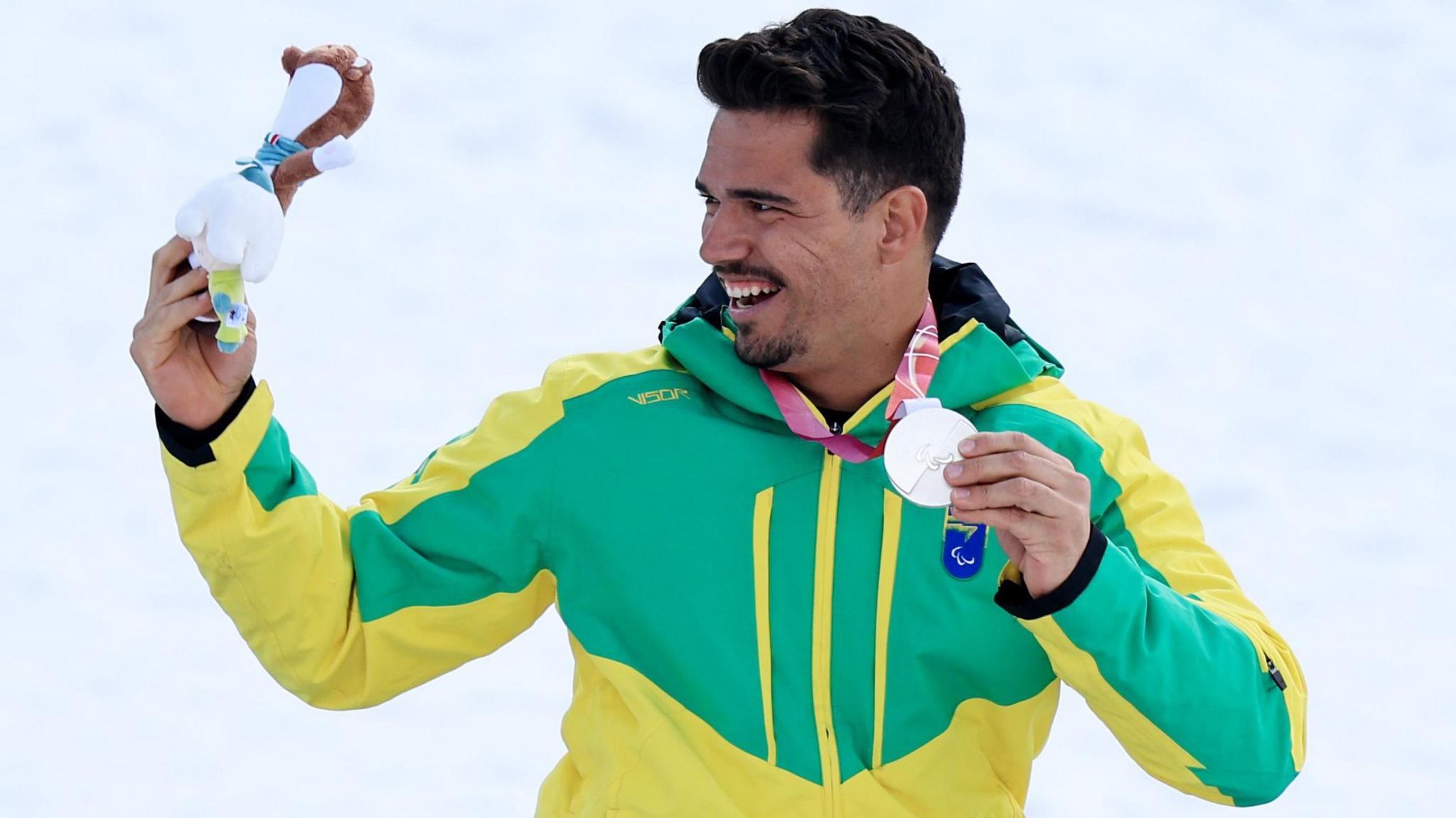 Cristian Westemaier Ribera holds his silver medal on the podium at the Winter Paralympics