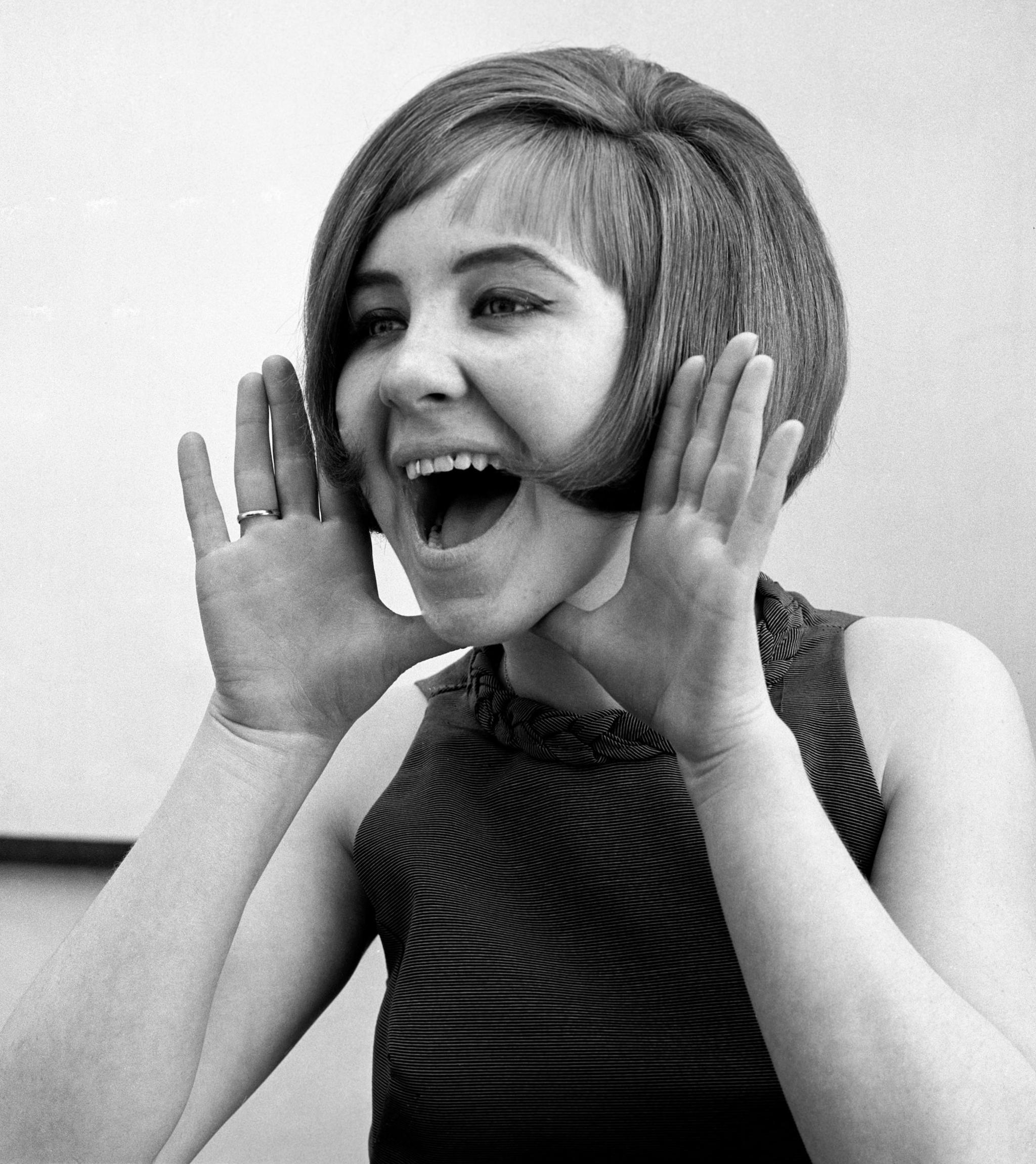 Lulu promotes her debut single, Shout, in 1964 - and is pictured holding her hands up to her mouth