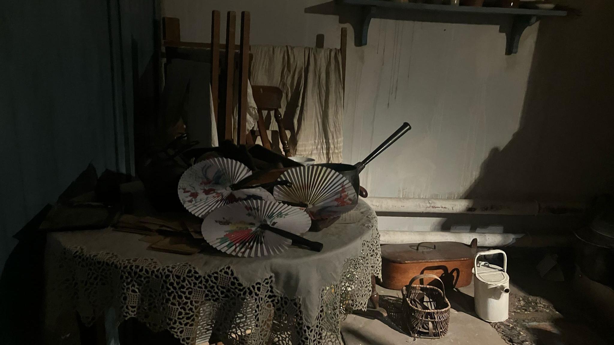 A traditional Victorian sitting room with baskets and fans on display.