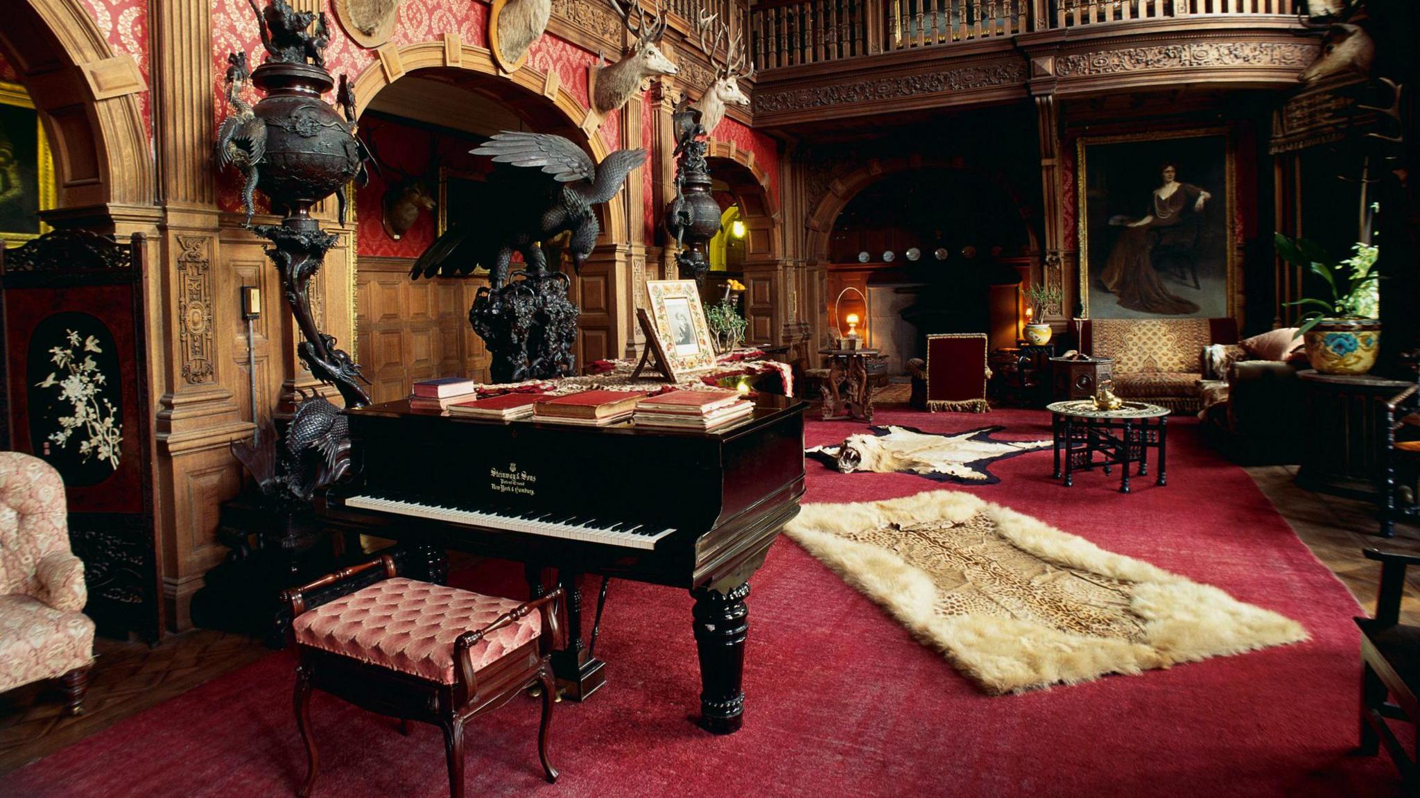 Seòmar leòmach am broinn Caisteal Cheann Loch le pìano, agus bratan-ùrlar le bèin bheathaichean 