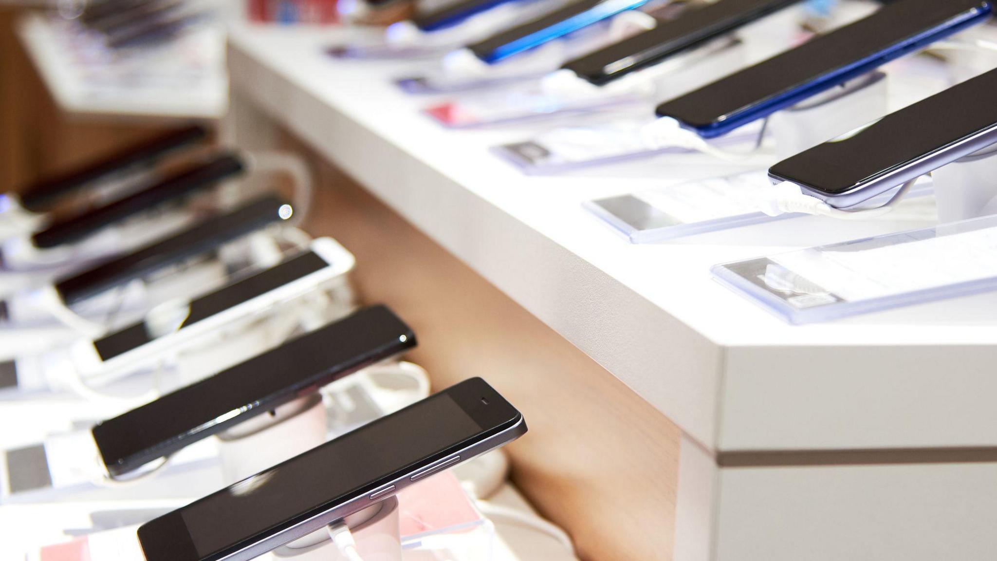 Smartphone's on the counter of a electronics store