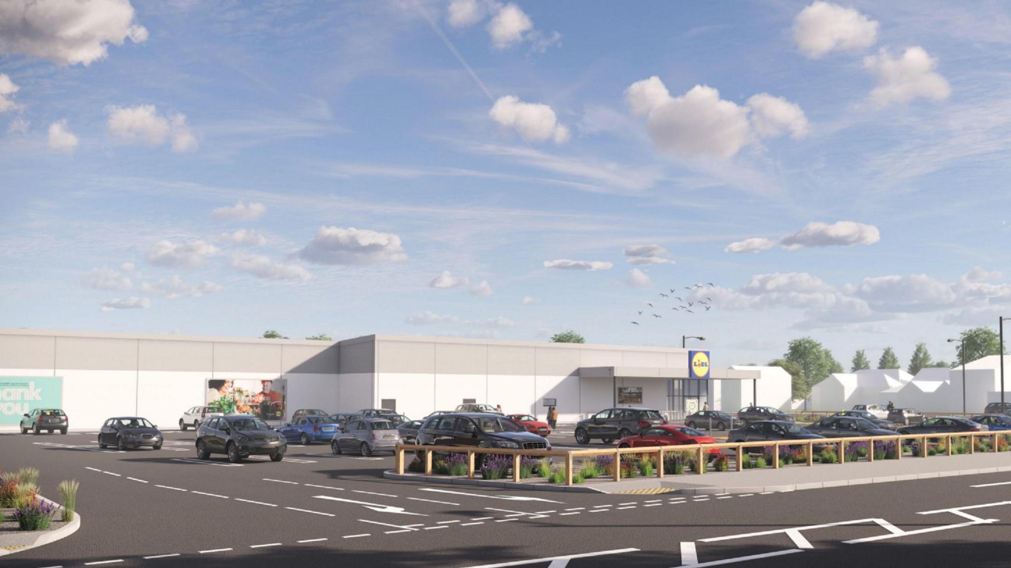 An artist's impression of the proposed Lidl site, showing a computer-generated image of a large white and grey supermarket with the blue and yellow Lidl logo on it. The sky is blue with a flock of birds above the supermarket. Lots of cars are in the car park which has a low wooden fence around it.