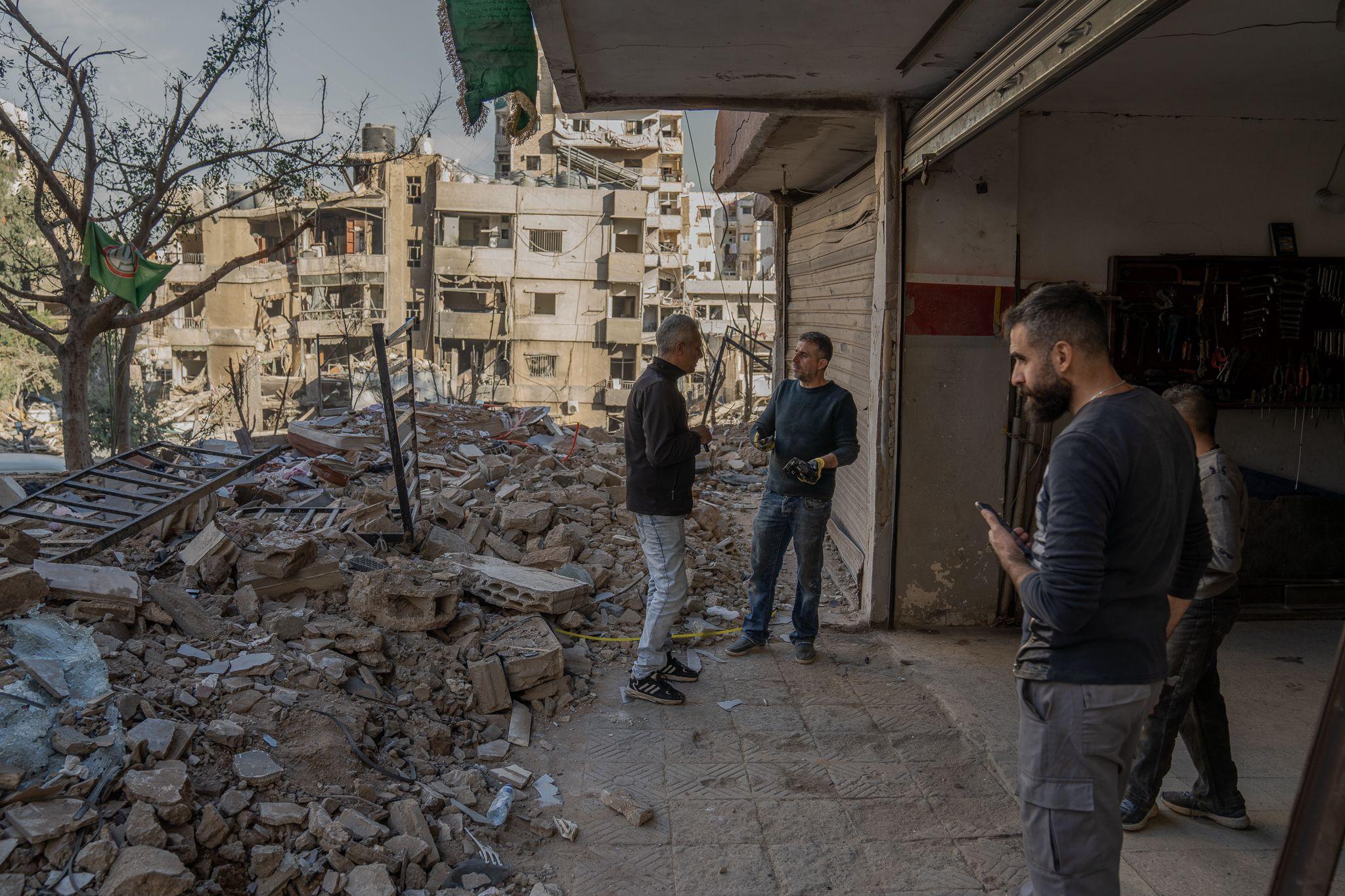 Ibrahim Mortada, second from left, clearing out the rubble from around his garage, which will have to be torn down.