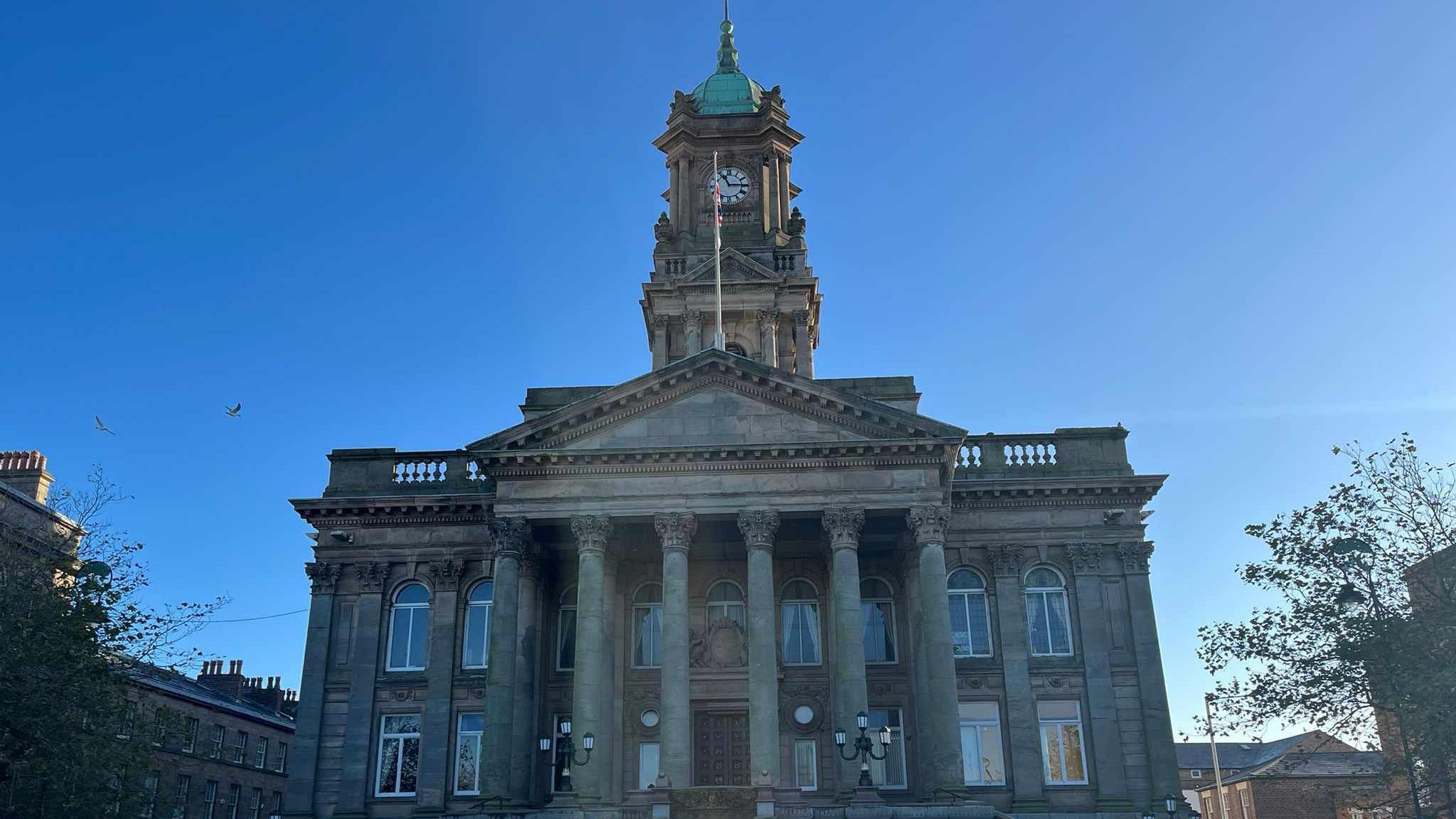 Birkenhead Town Hall including the clock tower. The neoclassical building  features six columns in front of the entrance. 