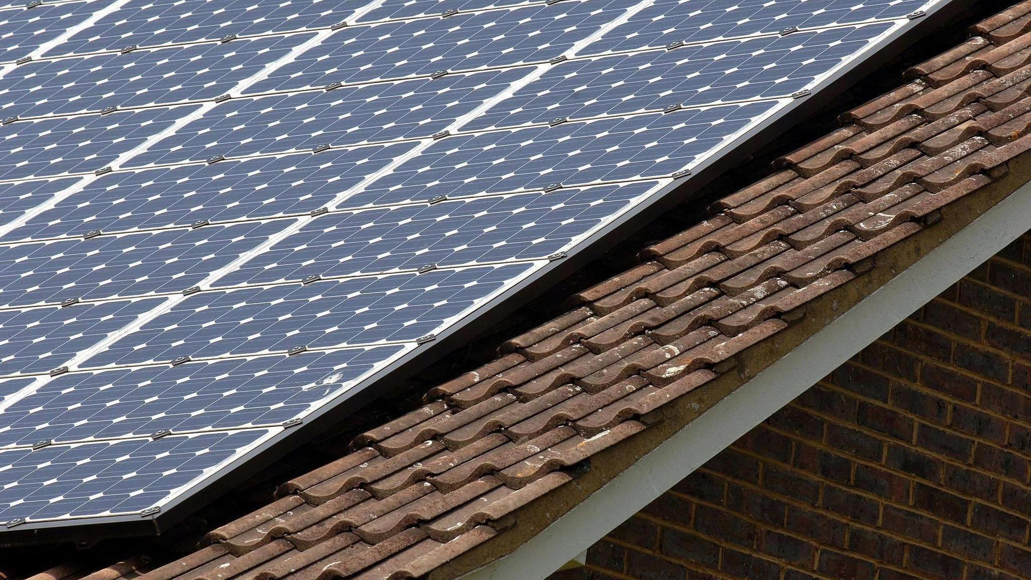 A building's slate roof where solar panels have been installed. 