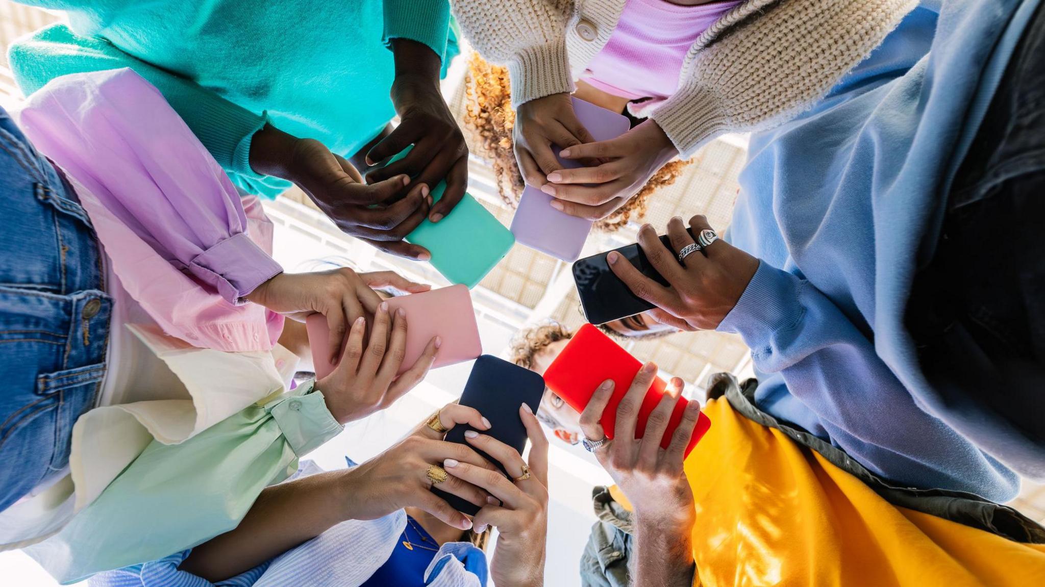 group of teenagers using phones. 