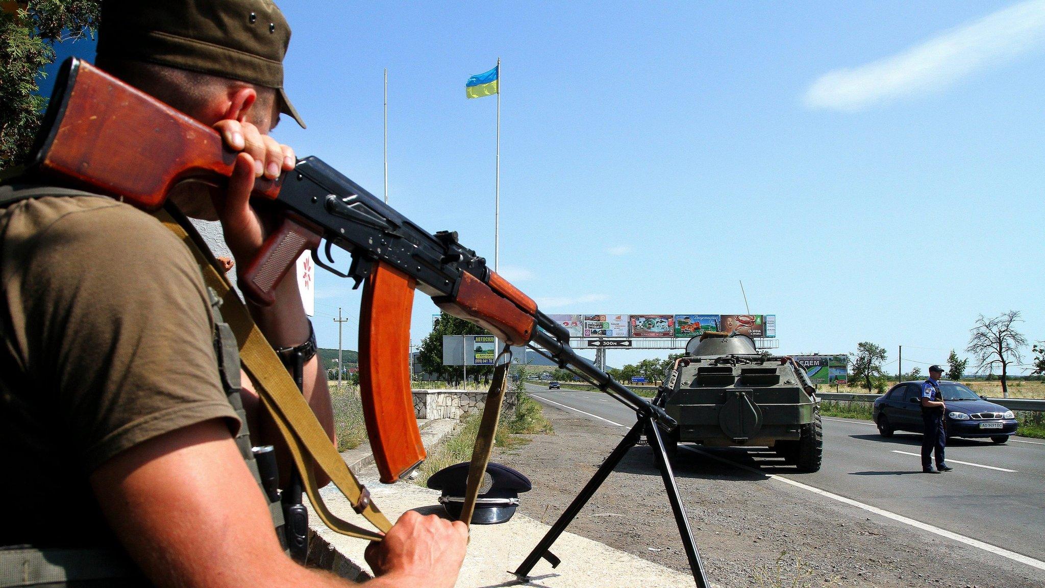 A Ukrainian serviceman guards the road at the border of the western city of Uzhhorod